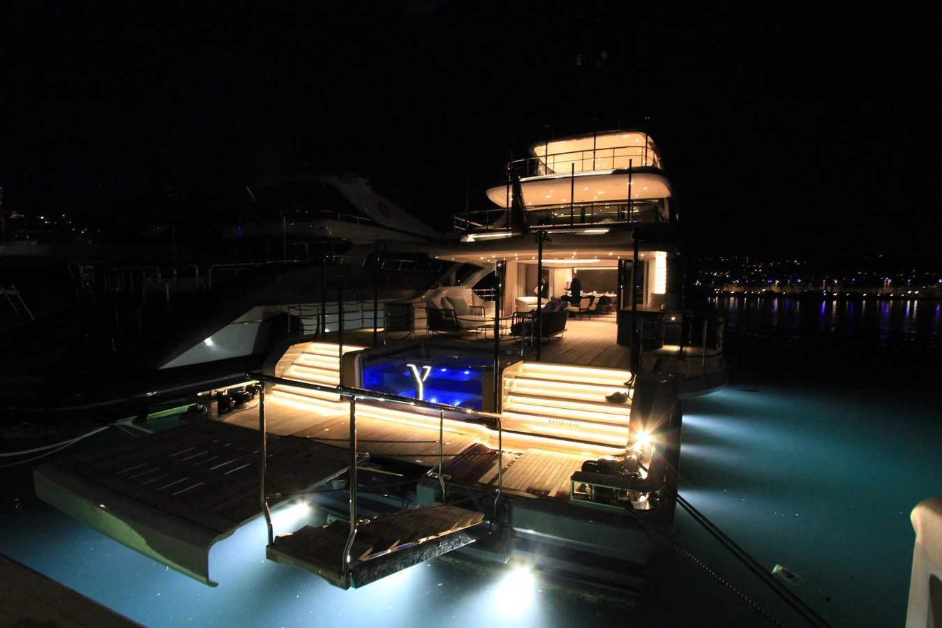 The yacht's aft deck is beautifully illuminated at night, showcasing its elegant design and inviting ambiance. aboard OASIS 34M BO212 Yacht for Sale