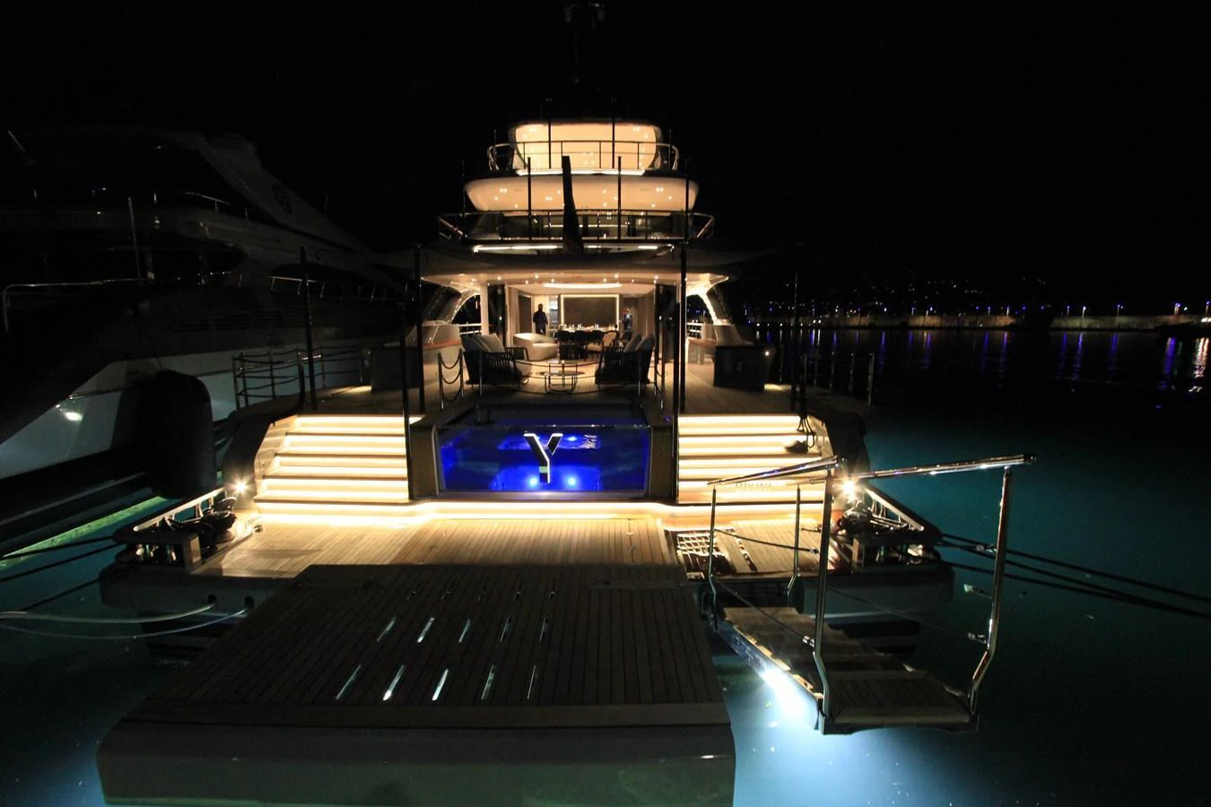 The yacht's aft deck is beautifully illuminated at night, showcasing a luxurious and inviting ambiance. aboard OASIS 34M BO212 Yacht for Sale