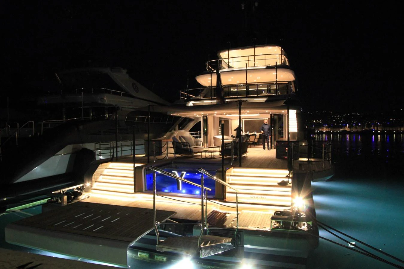 The yacht's aft deck is beautifully illuminated at night, showcasing a luxurious and inviting ambiance. aboard OASIS 34M BO212 Yacht for Sale