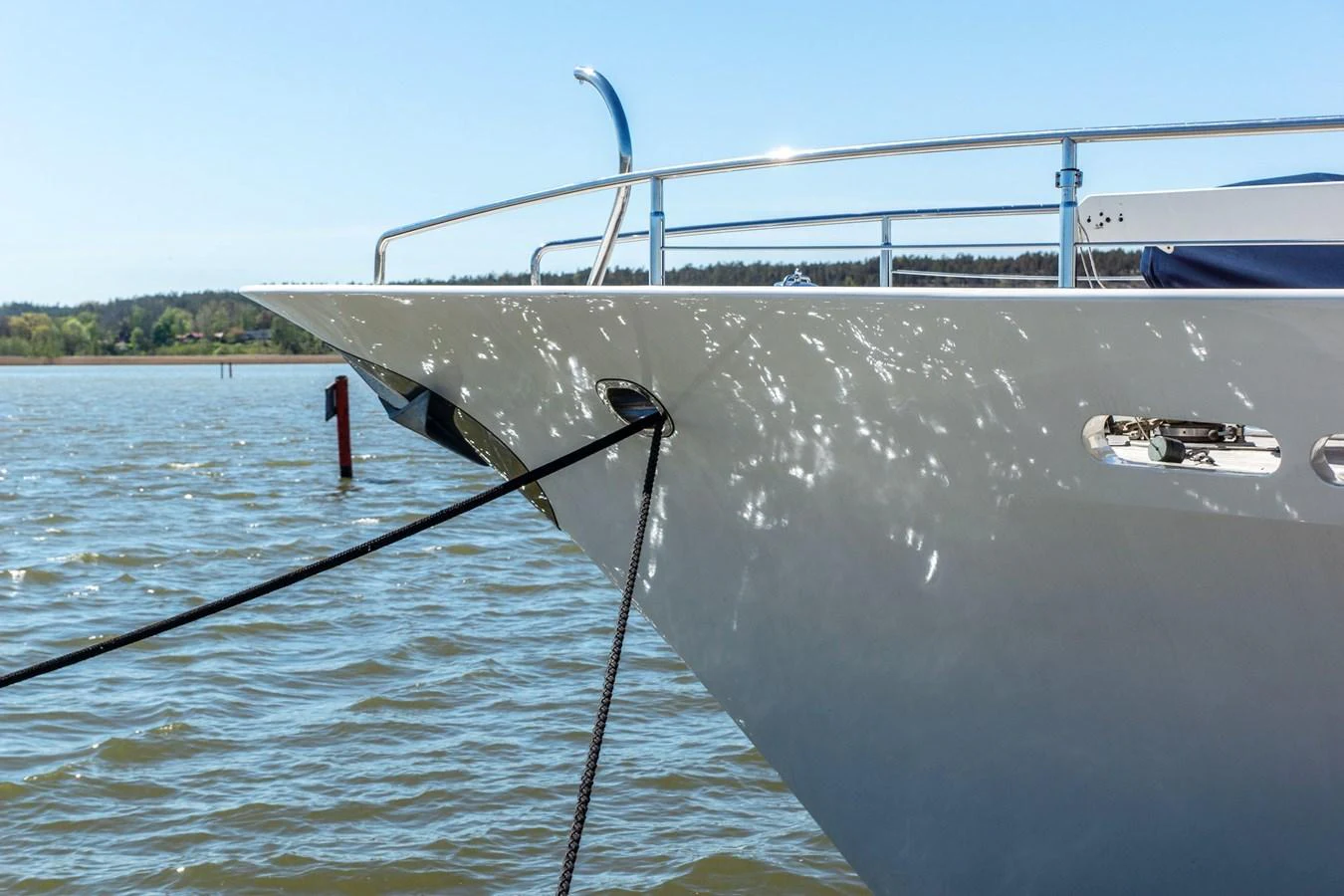 The sleek bow of the yacht is anchored, reflecting sunlight off its polished surface. aboard UNITED SPIRIT Yacht for Sale
