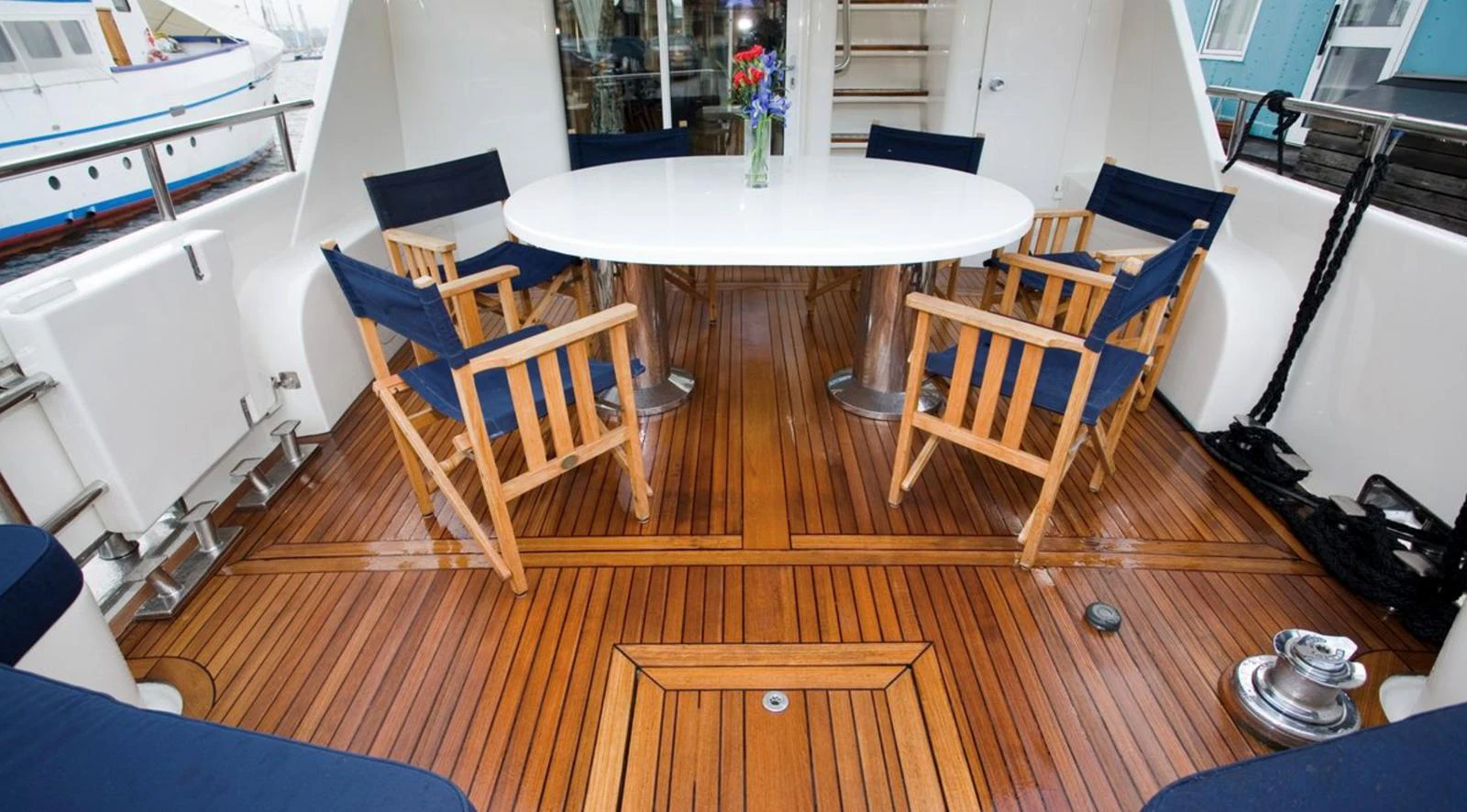 The aft deck features a stylish dining area with a round table and comfortable chairs, perfect for alfresco meals. aboard UNITED SPIRIT Yacht for Sale