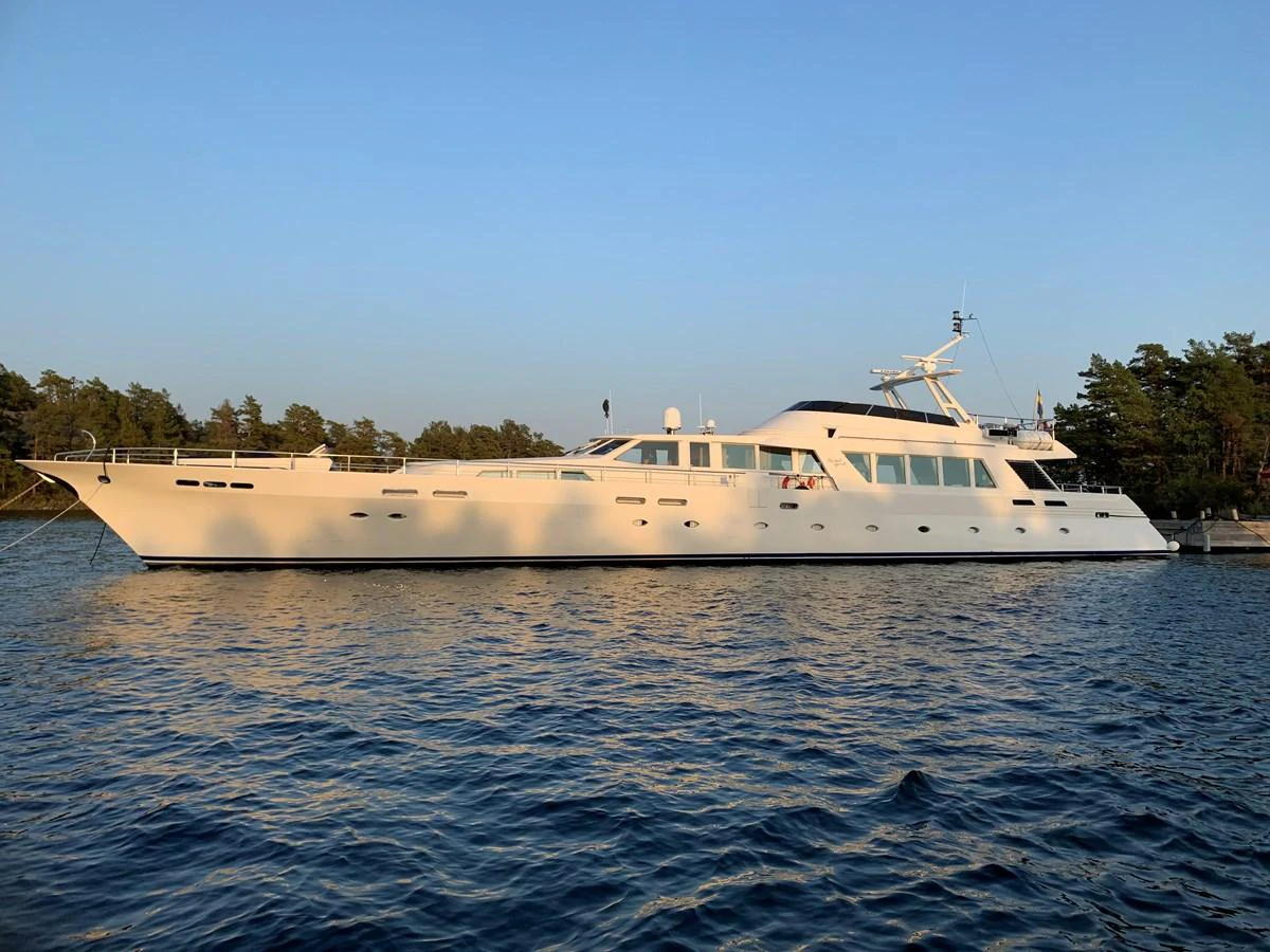 A sleek and elegant yacht cruises on calm waters under a clear sky. aboard UNITED SPIRIT Yacht for Sale