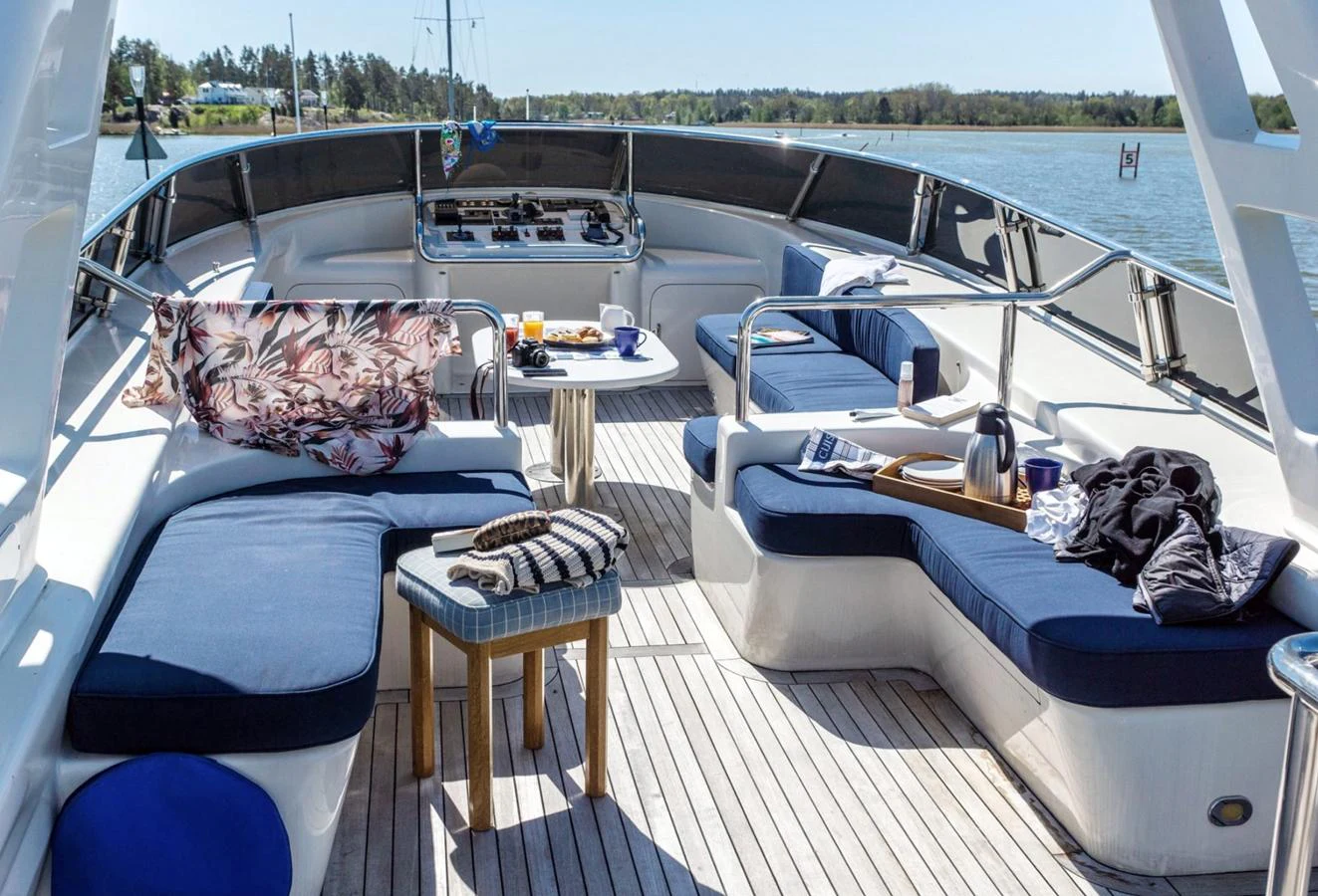 The flybridge offers a comfortable seating area with a table, perfect for enjoying meals and drinks while taking in the scenic views. aboard UNITED SPIRIT Yacht for Sale