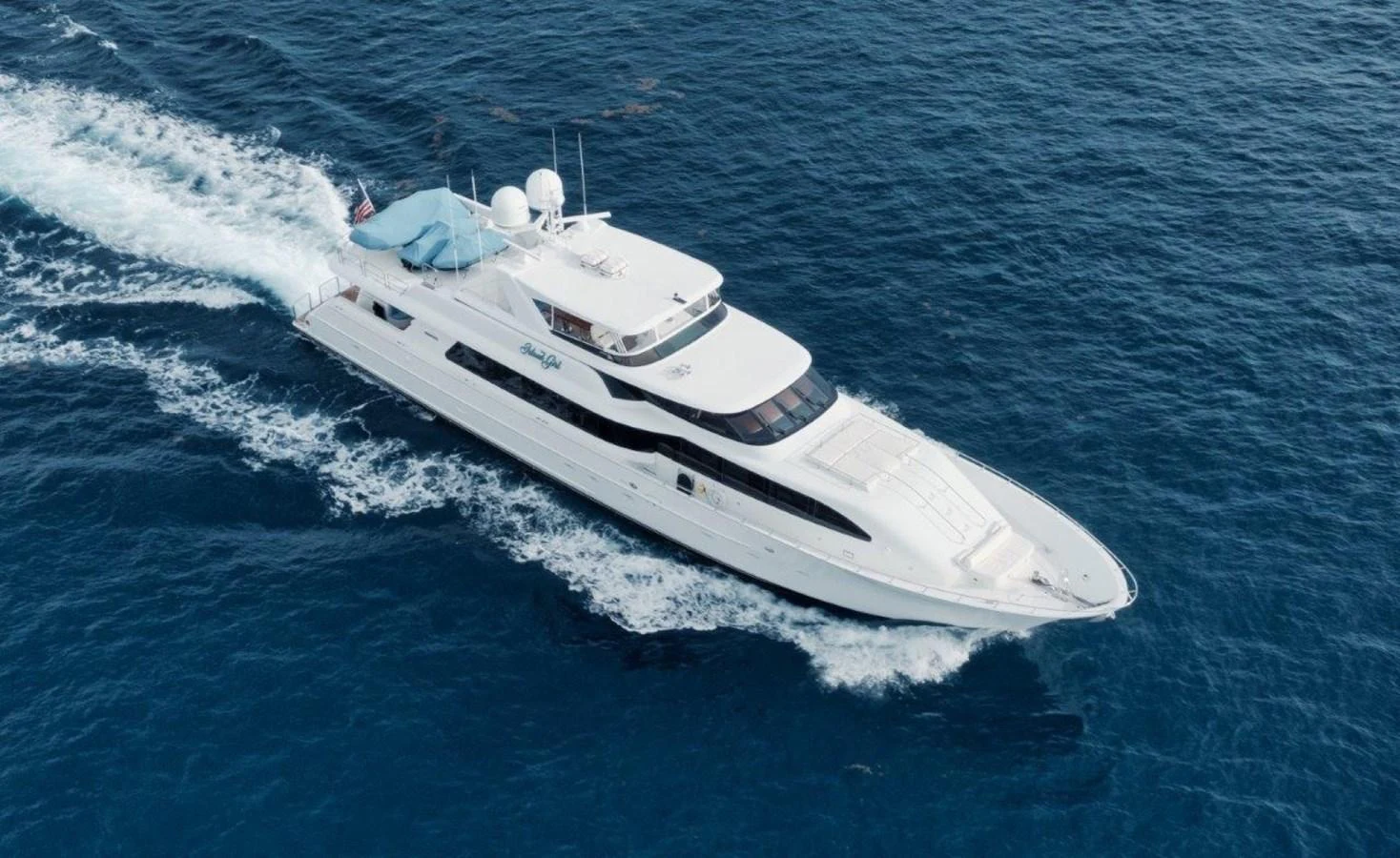 A sleek white yacht cruises through the deep blue ocean, showcasing its elegant design and powerful performance. aboard ISLAND GIRL Yacht for Sale