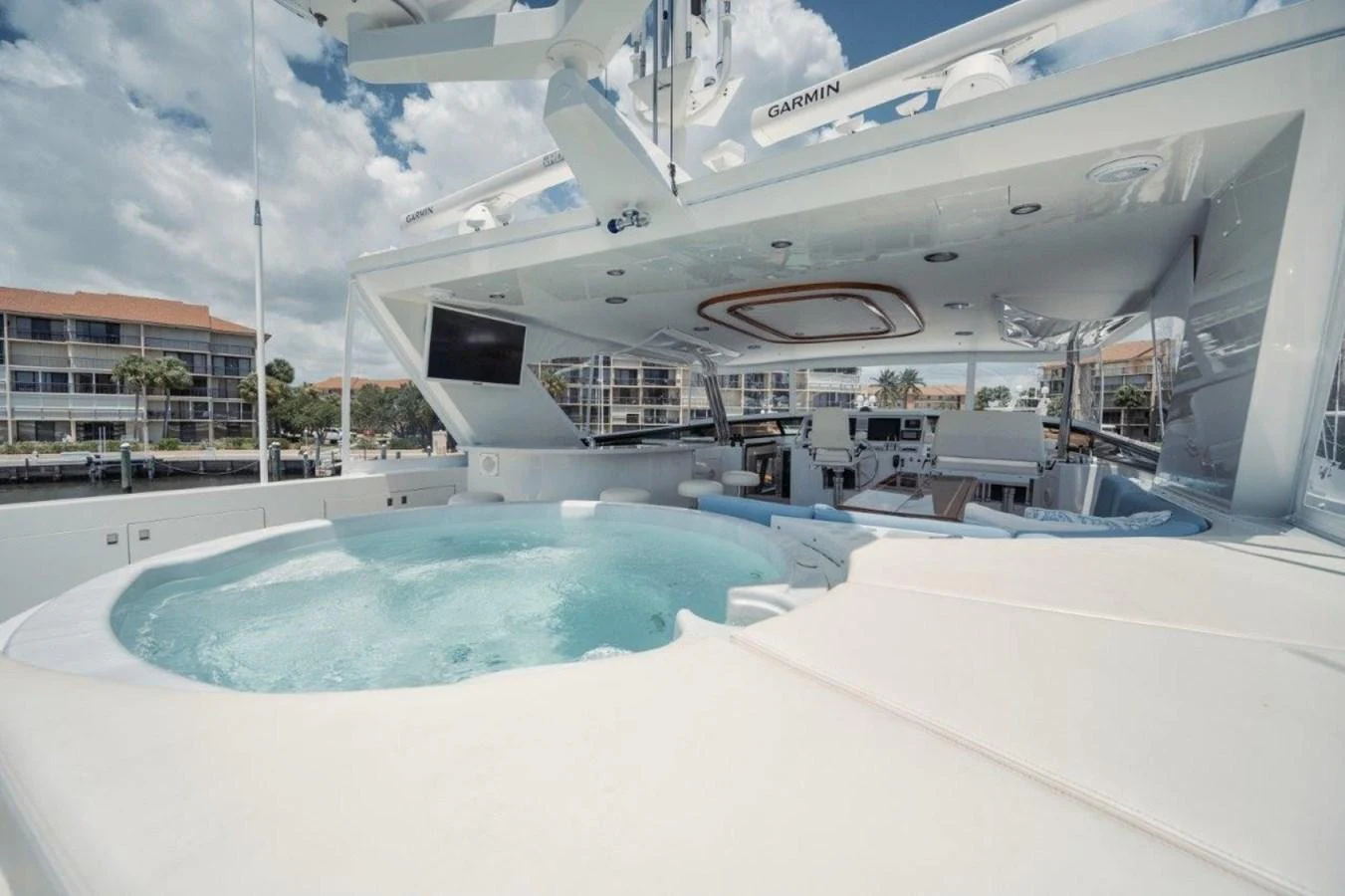 The sundeck features a luxurious jacuzzi and ample lounging space under a clear sky. aboard ISLAND GIRL Yacht for Sale