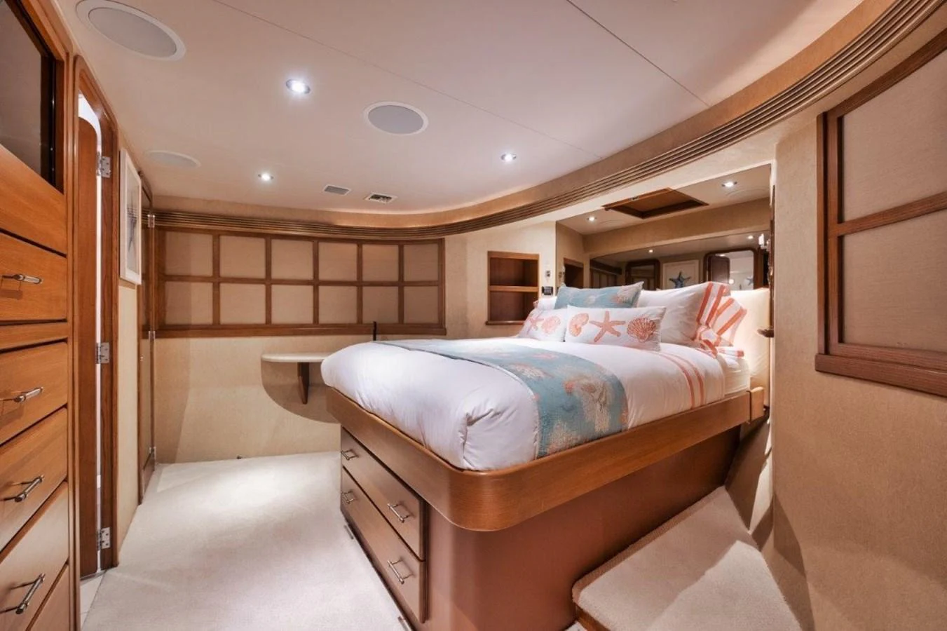 The stateroom features a luxurious bed with elegant wood finishes and soft lighting. aboard ISLAND GIRL Yacht for Sale