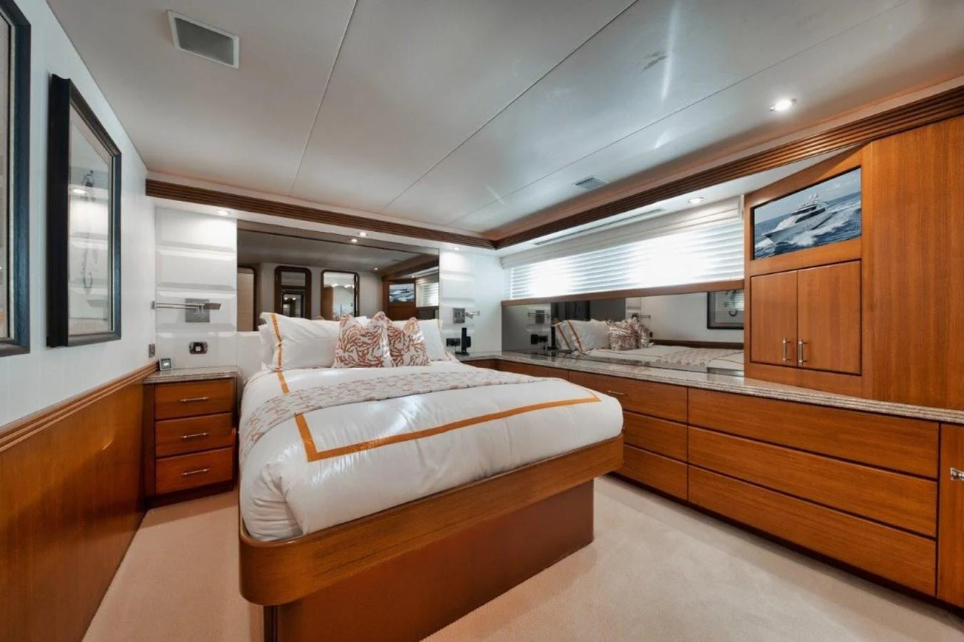 The stateroom features a luxurious bed with elegant wood finishes and ample storage space. aboard ISLAND GIRL Yacht for Sale