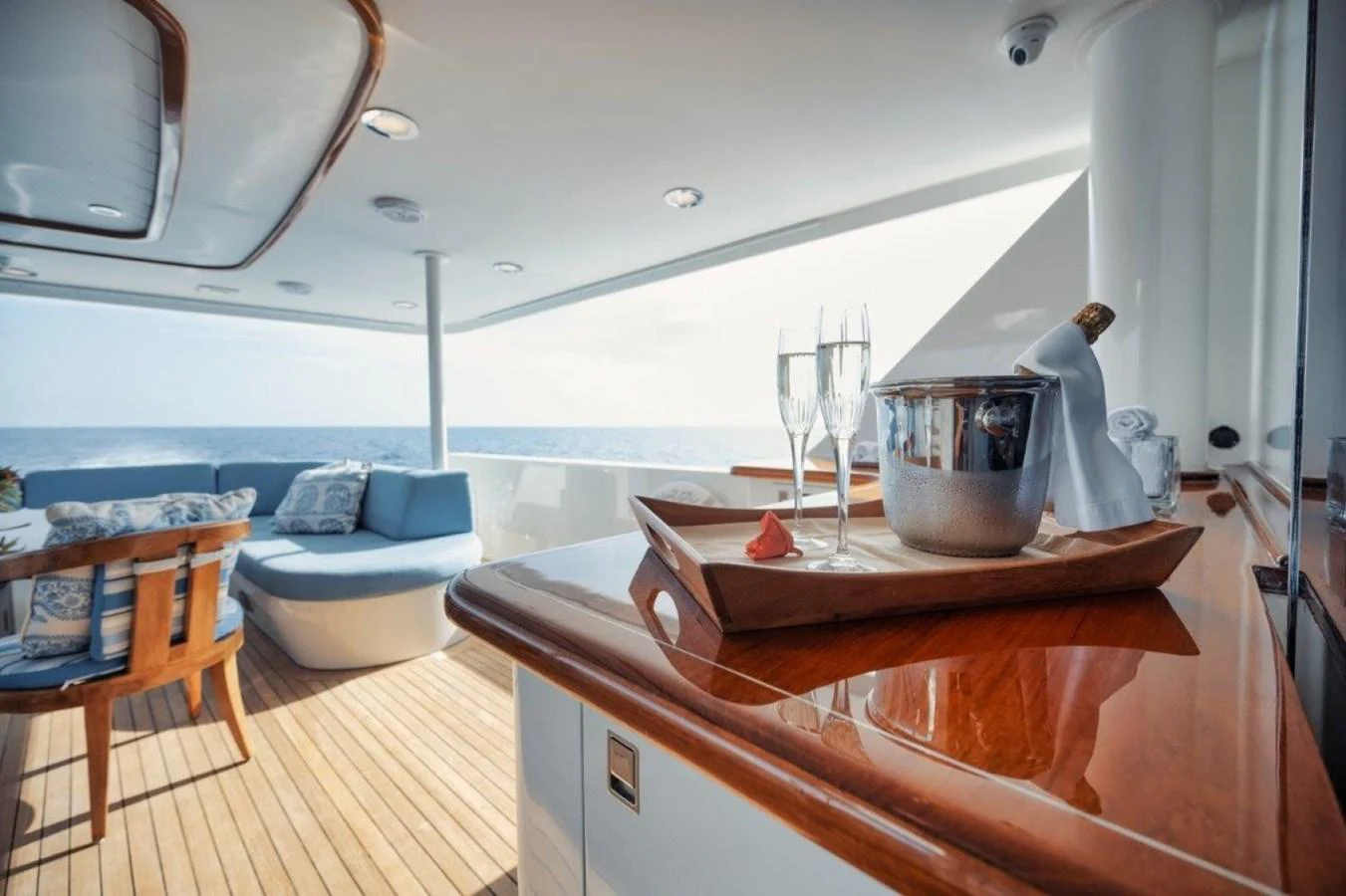 The aft deck offers a luxurious setting with a champagne bucket and glasses, perfect for relaxation and enjoying the ocean view. aboard ISLAND GIRL Yacht for Sale