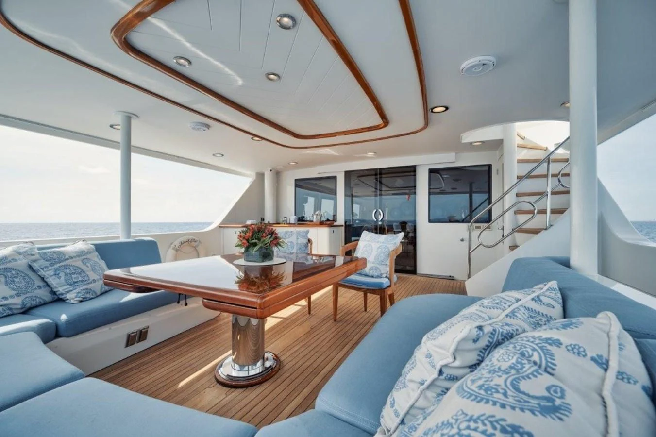 The aft deck features a spacious seating area with plush cushions and a polished wooden table, perfect for relaxation and dining. aboard ISLAND GIRL Yacht for Sale