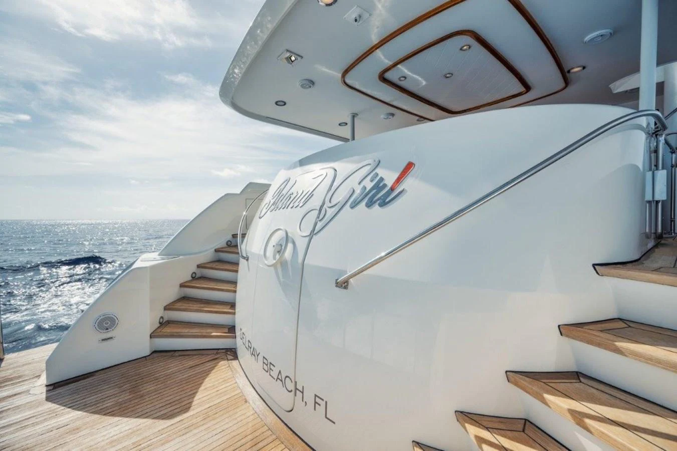 The aft deck of the yacht features elegant wooden steps and a sleek design, perfect for enjoying the ocean view. aboard ISLAND GIRL Yacht for Sale