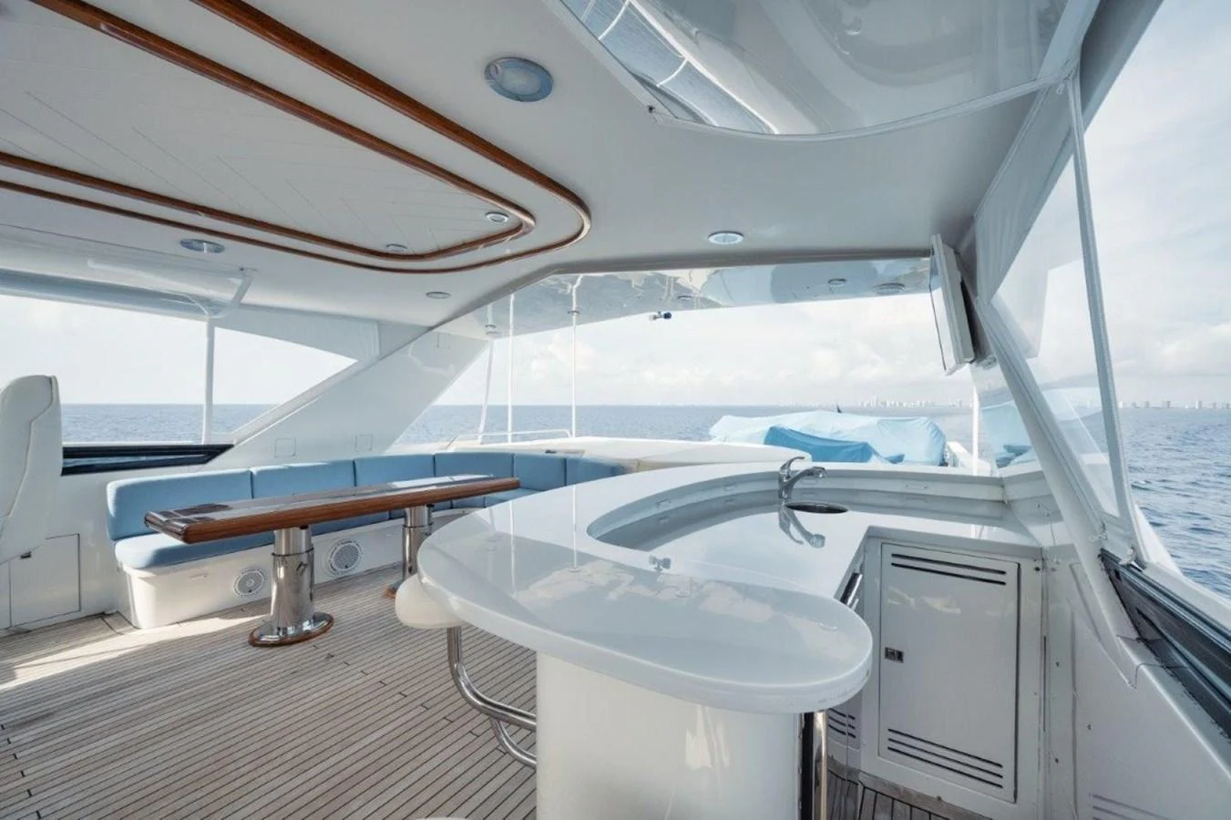 The flybridge offers a spacious and stylish area with ample seating and a sleek bar counter, perfect for entertaining while enjoying panoramic ocean views. aboard ISLAND GIRL Yacht for Sale