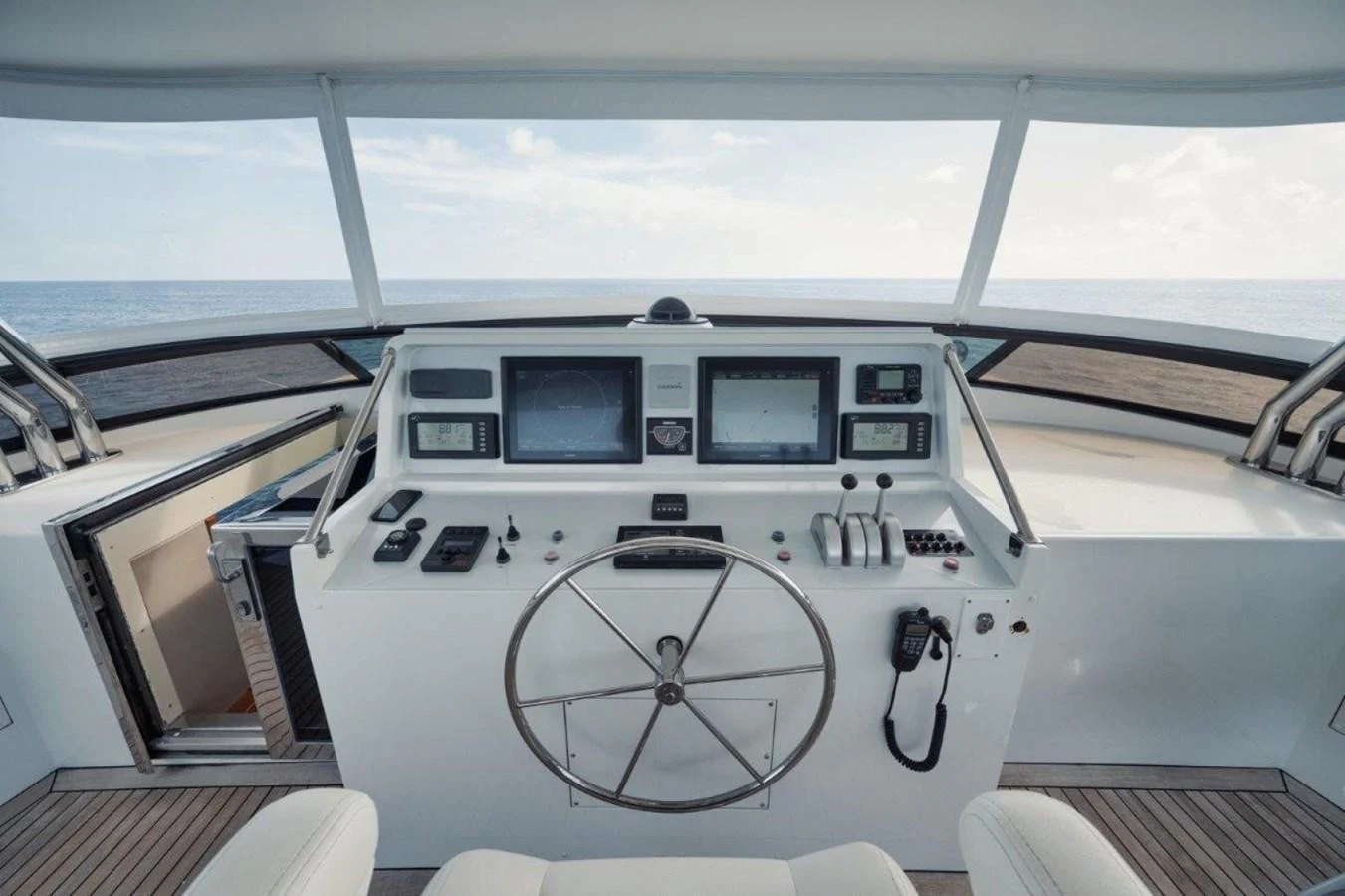 The helm station offers a commanding view with state-of-the-art navigation equipment and a sleek design. aboard ISLAND GIRL Yacht for Sale