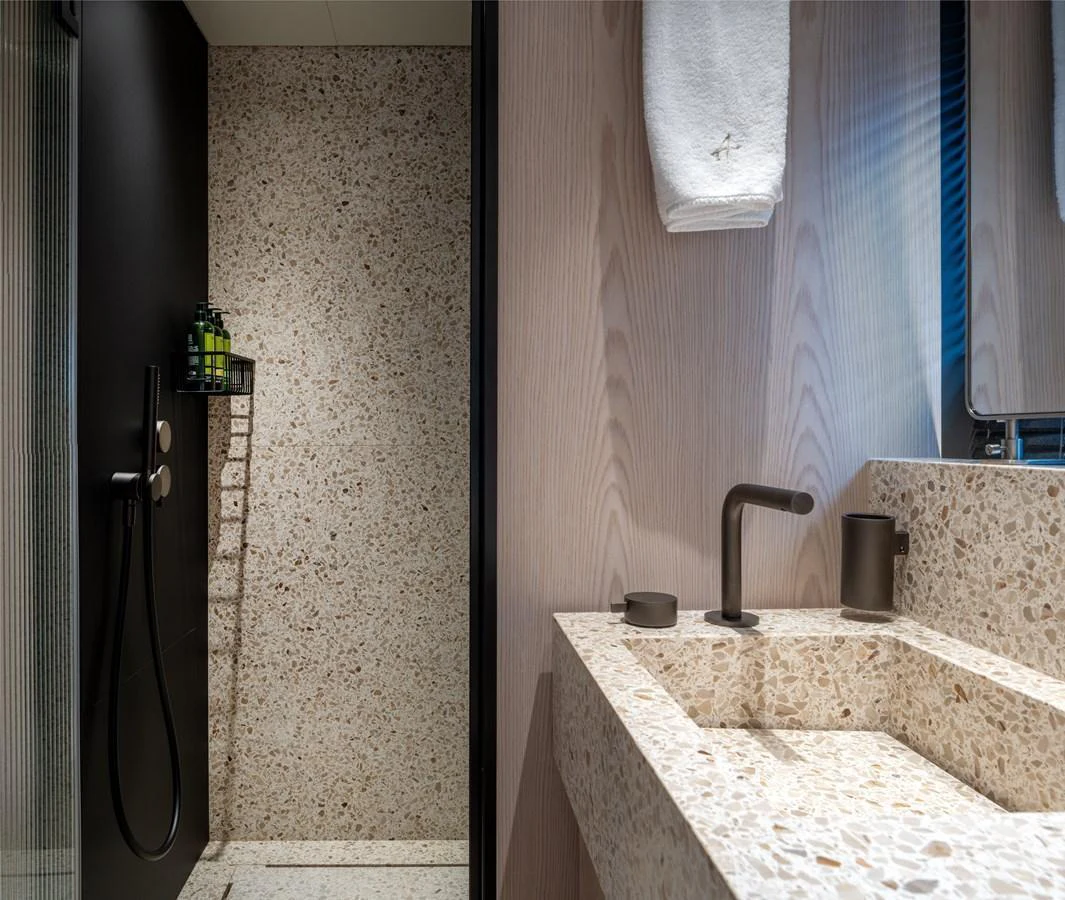 The bathroom features a modern design with a terrazzo sink and shower area. aboard A+ Yacht for Sale