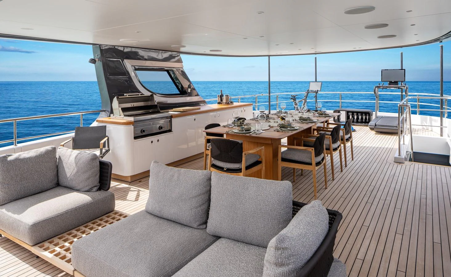 The aft deck features a spacious dining area and comfortable lounging space with stunning ocean views. aboard A+ Yacht for Sale