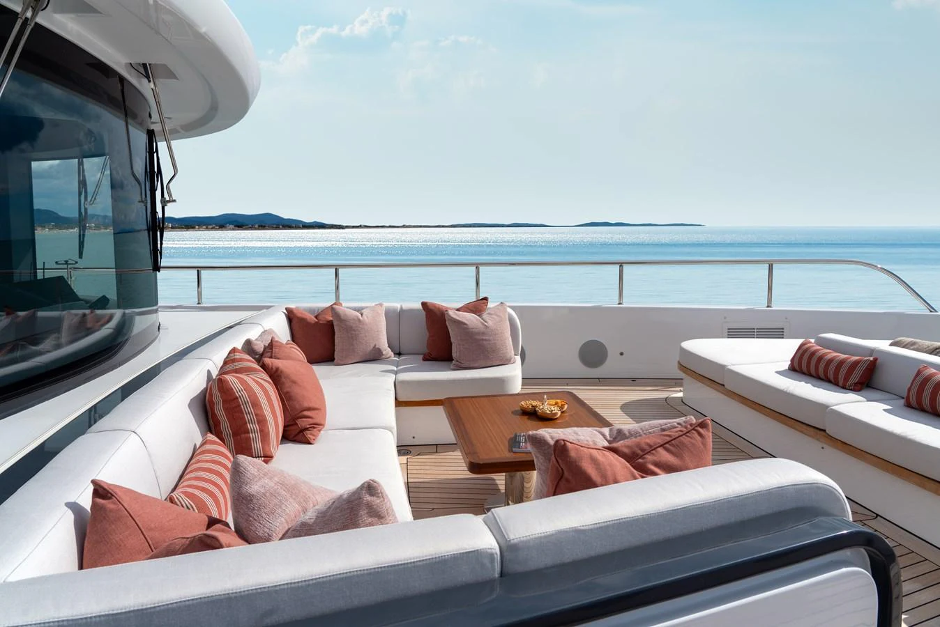 The aft deck features a luxurious seating area with plush cushions and a stunning ocean view. aboard A+ Yacht for Sale