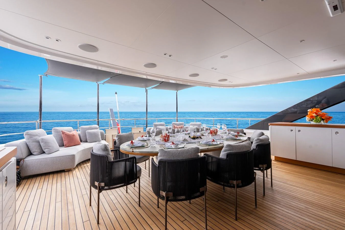 The aft deck features an elegant dining area with a stunning ocean view. aboard A+ Yacht for Sale