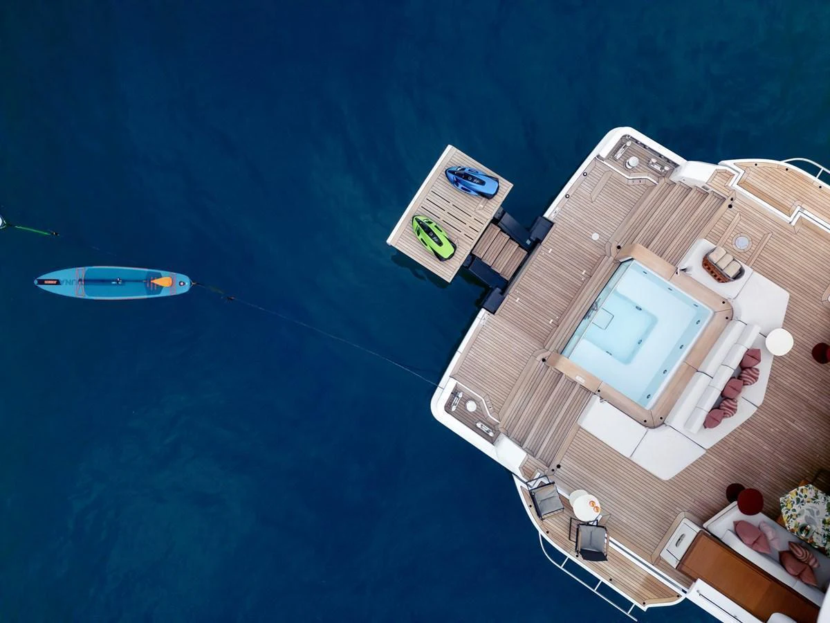 The aft deck features a luxurious hot tub and a small platform with water toys, perfect for relaxation and fun. aboard A+ Yacht for Sale