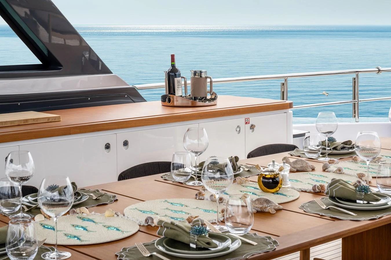 An elegant alfresco dining area set with fine tableware and a stunning ocean view. aboard A+ Yacht for Sale