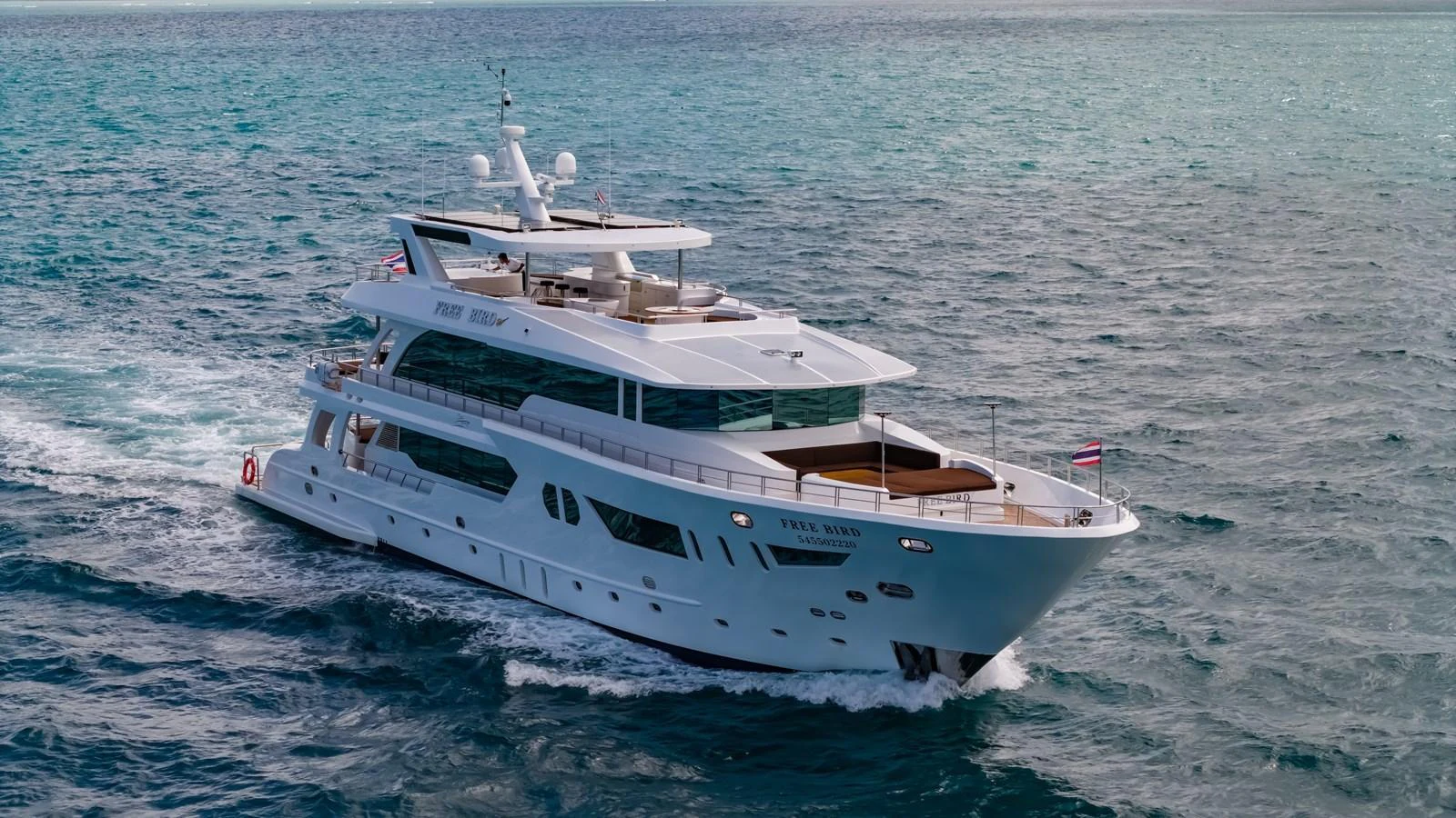 A luxurious yacht cruises through the open sea, showcasing its elegant design and spacious decks. aboard FREE BIRD Yacht for Sale