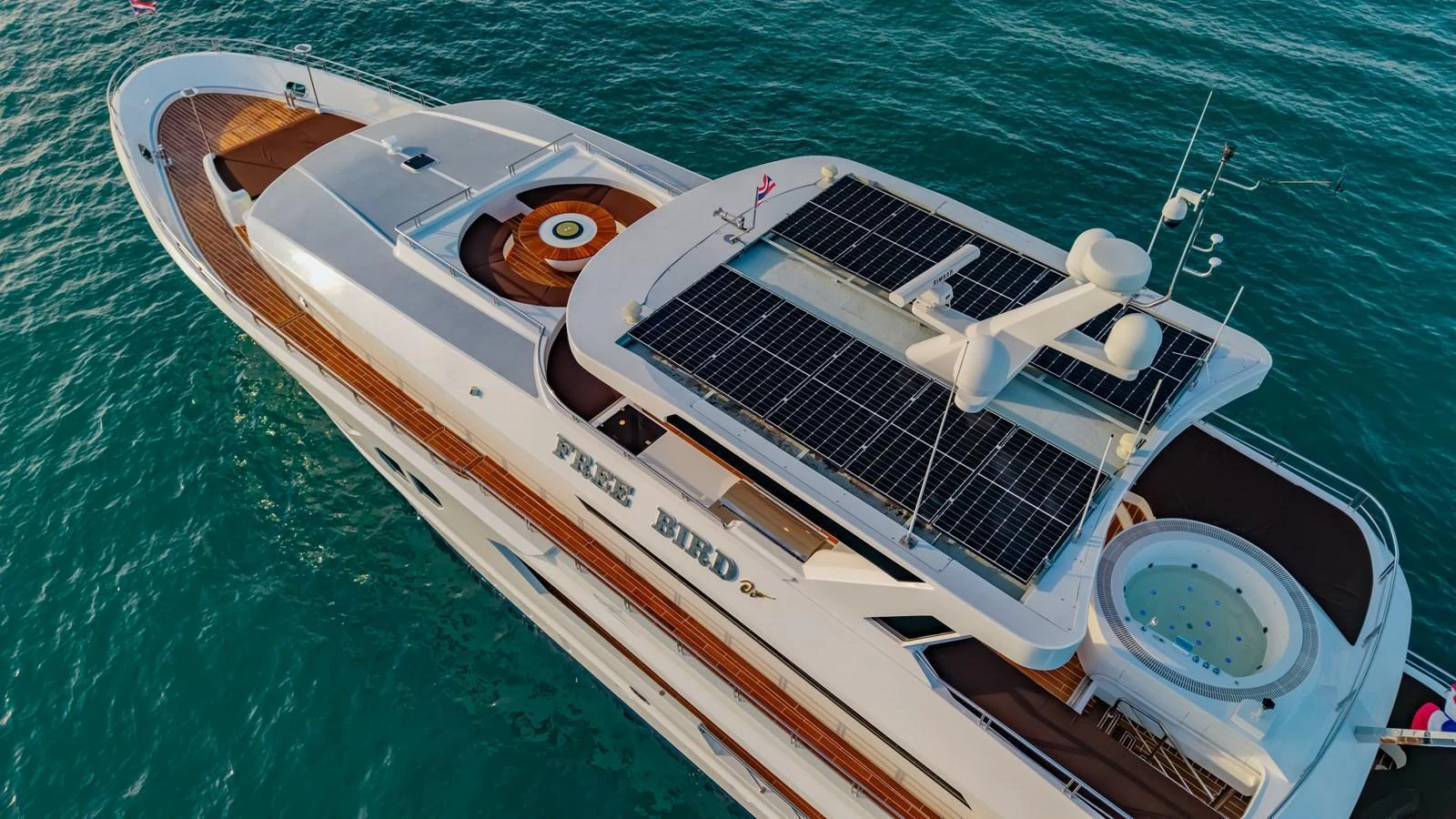The yacht's sundeck features solar panels, a jacuzzi, and ample lounging space, all set against the backdrop of serene waters. aboard FREE BIRD Yacht for Sale