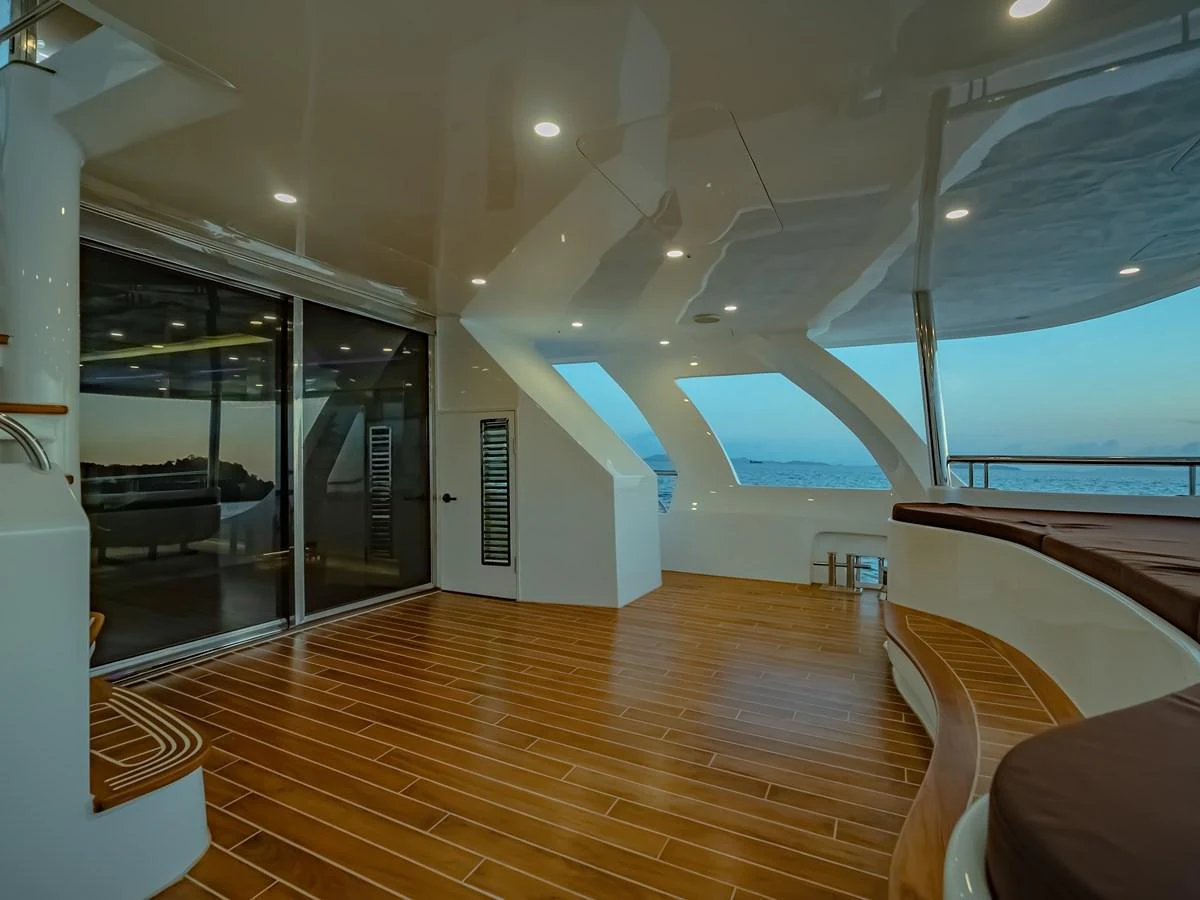 The aft deck features a spacious and elegant area with wooden flooring and ample seating, perfect for relaxation and enjoying the view. aboard FREE BIRD Yacht for Sale