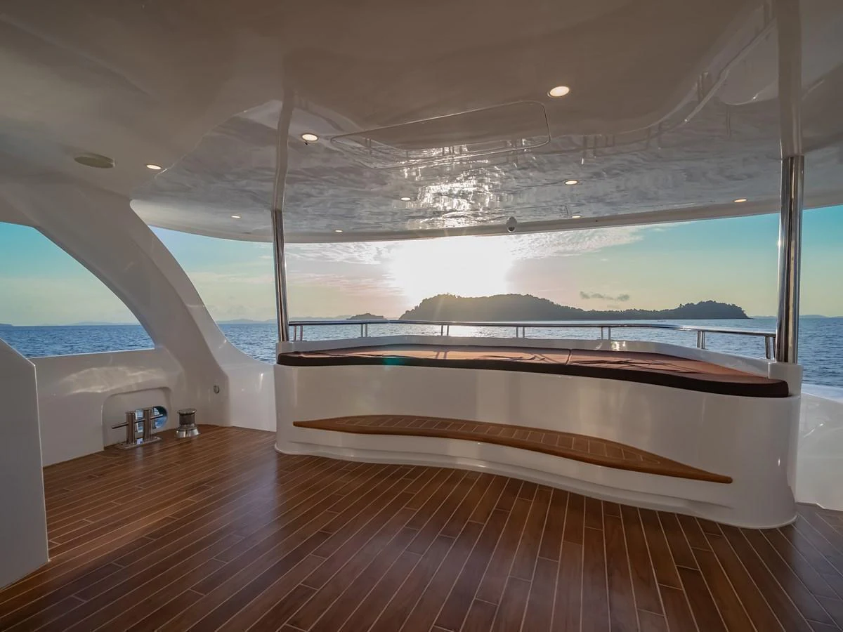 The aft deck offers a serene space with a stunning view of the ocean and islands in the distance. aboard FREE BIRD Yacht for Sale