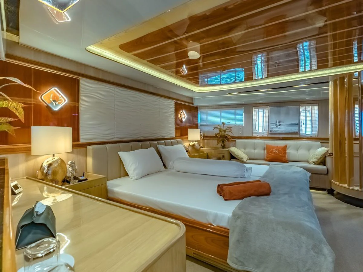 The master stateroom exudes luxury with its plush bedding and elegant wood finishes. aboard FREE BIRD Yacht for Sale