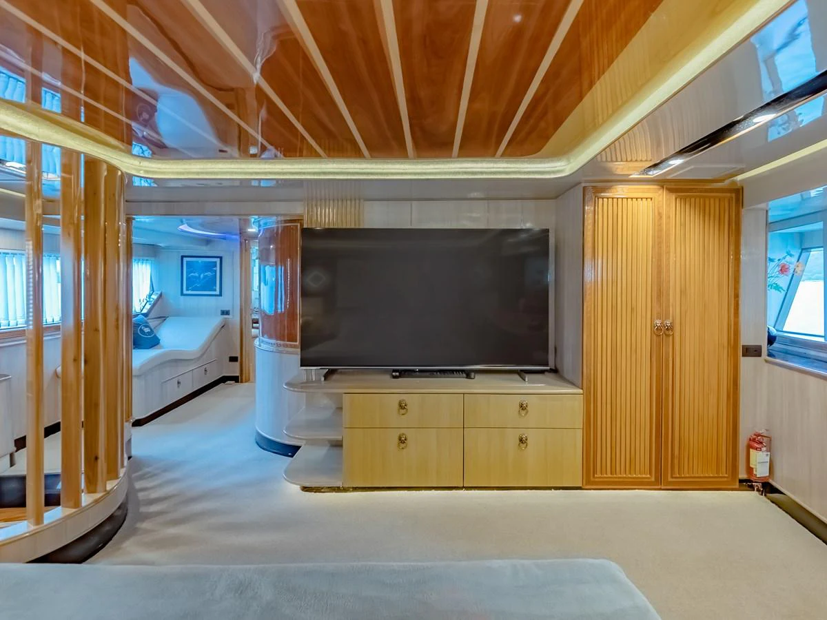 The yacht's interior features a spacious and elegant living area with a large flat-screen TV and luxurious wood finishes. aboard FREE BIRD Yacht for Sale
