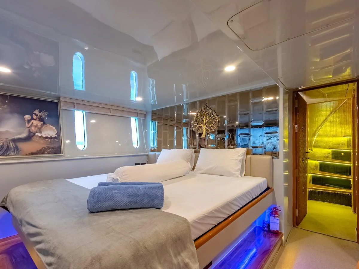 A luxurious stateroom featuring a comfortable bed with plush linens and ambient lighting. aboard FREE BIRD Yacht for Sale