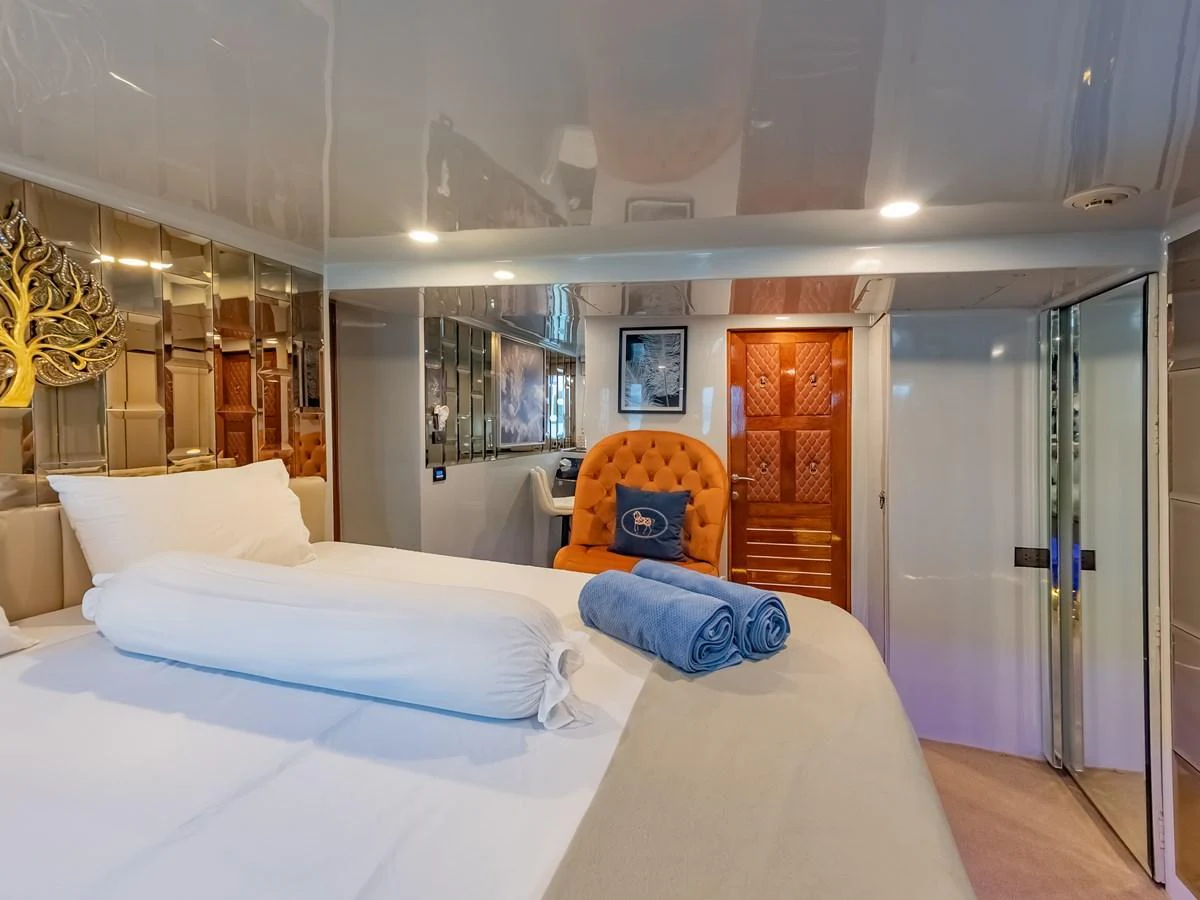 The stateroom features a plush bed with luxurious linens and elegant decor. aboard FREE BIRD Yacht for Sale