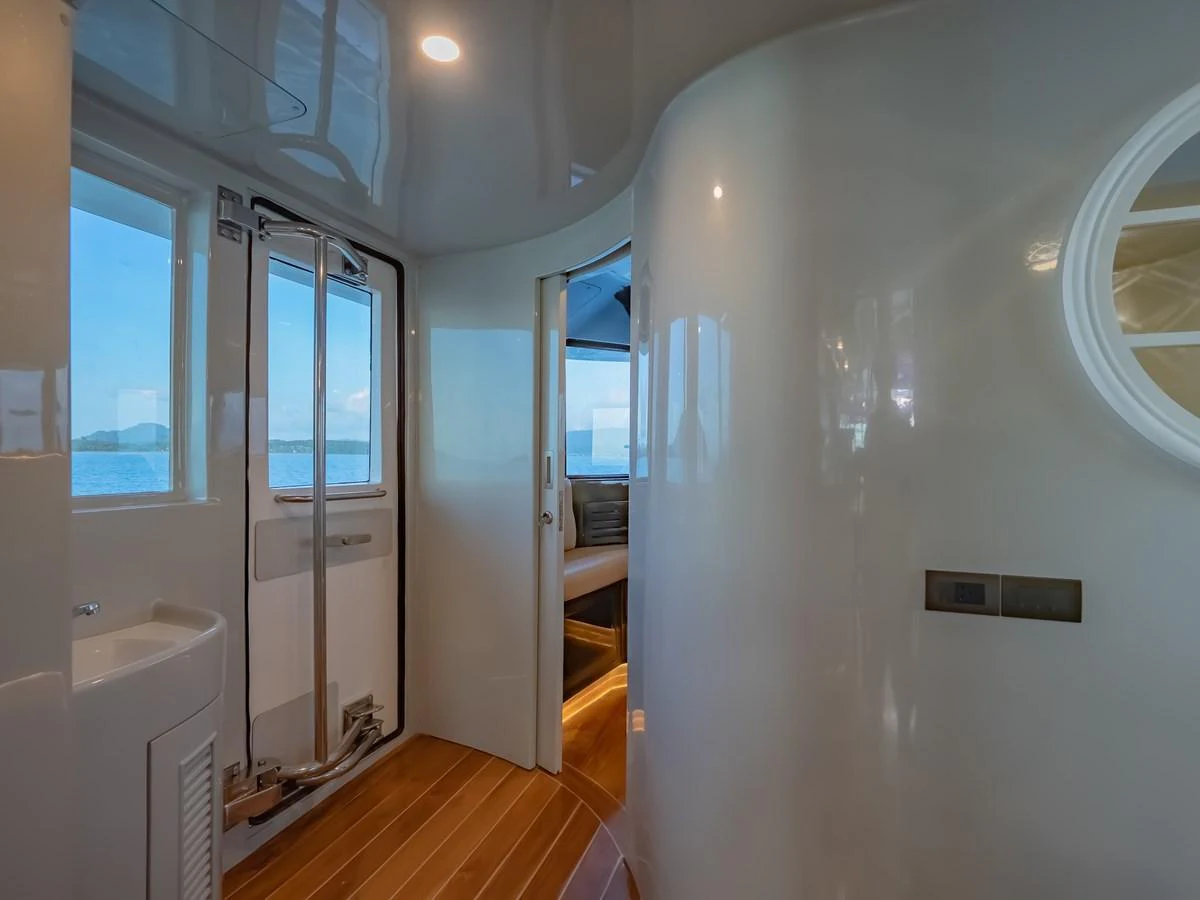 A sleek and modern interior passageway with a view of the sea through the windows. aboard FREE BIRD Yacht for Sale