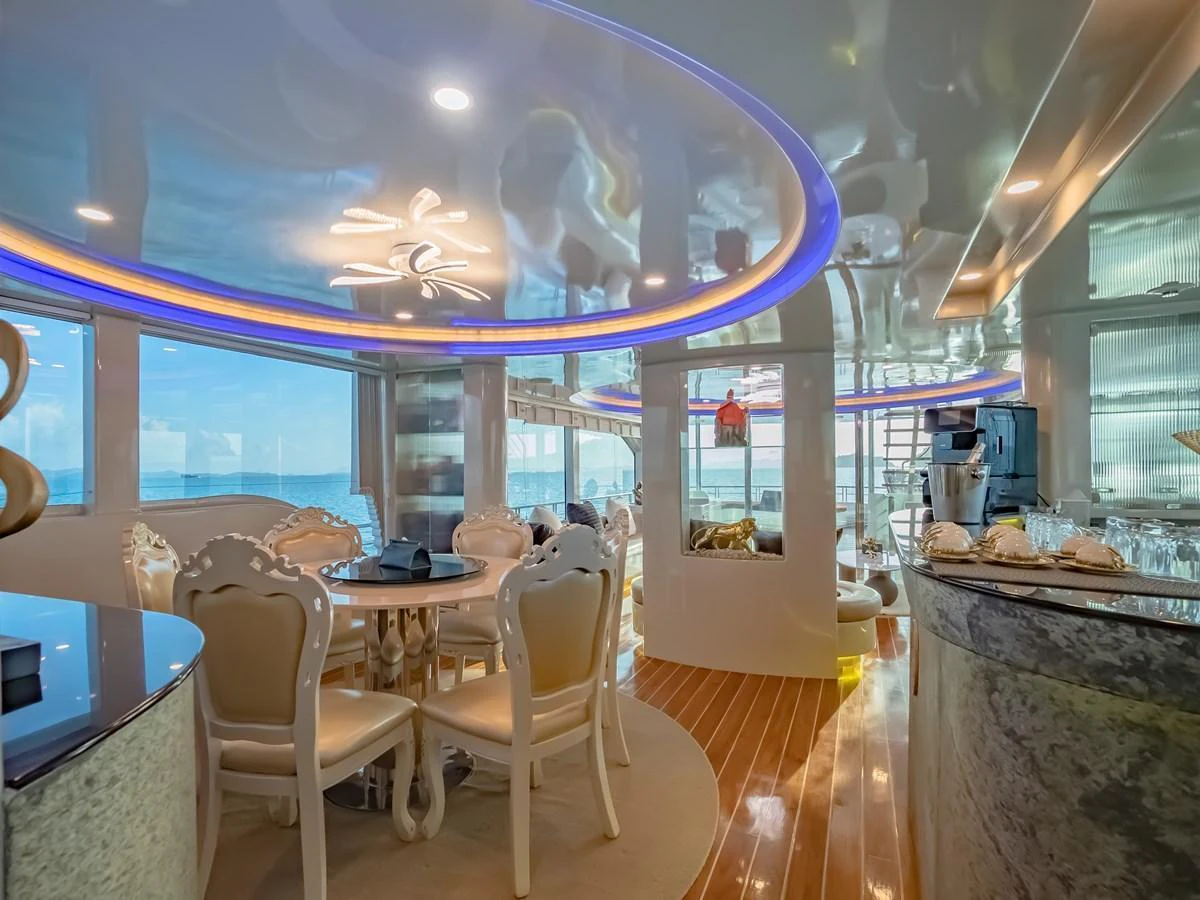 The yacht's salon features elegant seating and dining areas with panoramic ocean views. aboard FREE BIRD Yacht for Sale