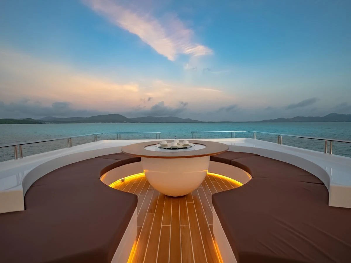 The sundeck features a stylish circular seating area with ambient lighting, perfect for enjoying panoramic ocean views. aboard FREE BIRD Yacht for Sale