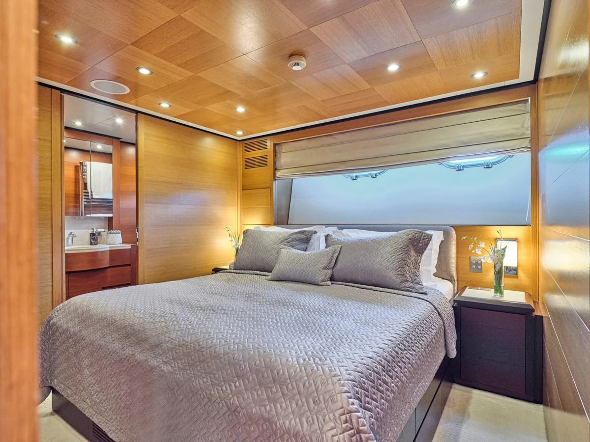 The master stateroom features a luxurious bed with elegant bedding and warm wooden accents. aboard VENETICO Yacht for Sale