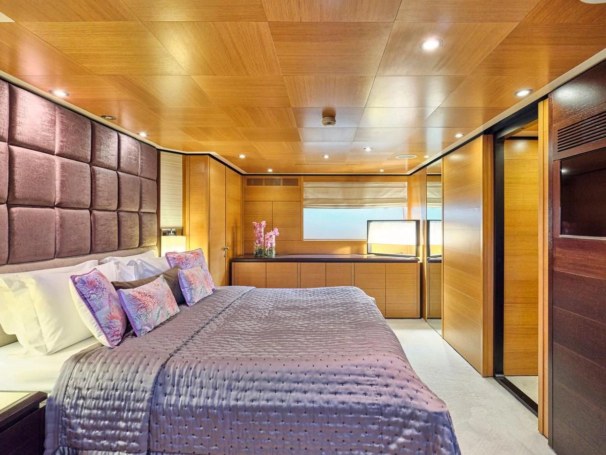 The master stateroom features luxurious bedding and elegant wood paneling, creating a serene and sophisticated atmosphere. aboard VENETICO Yacht for Sale