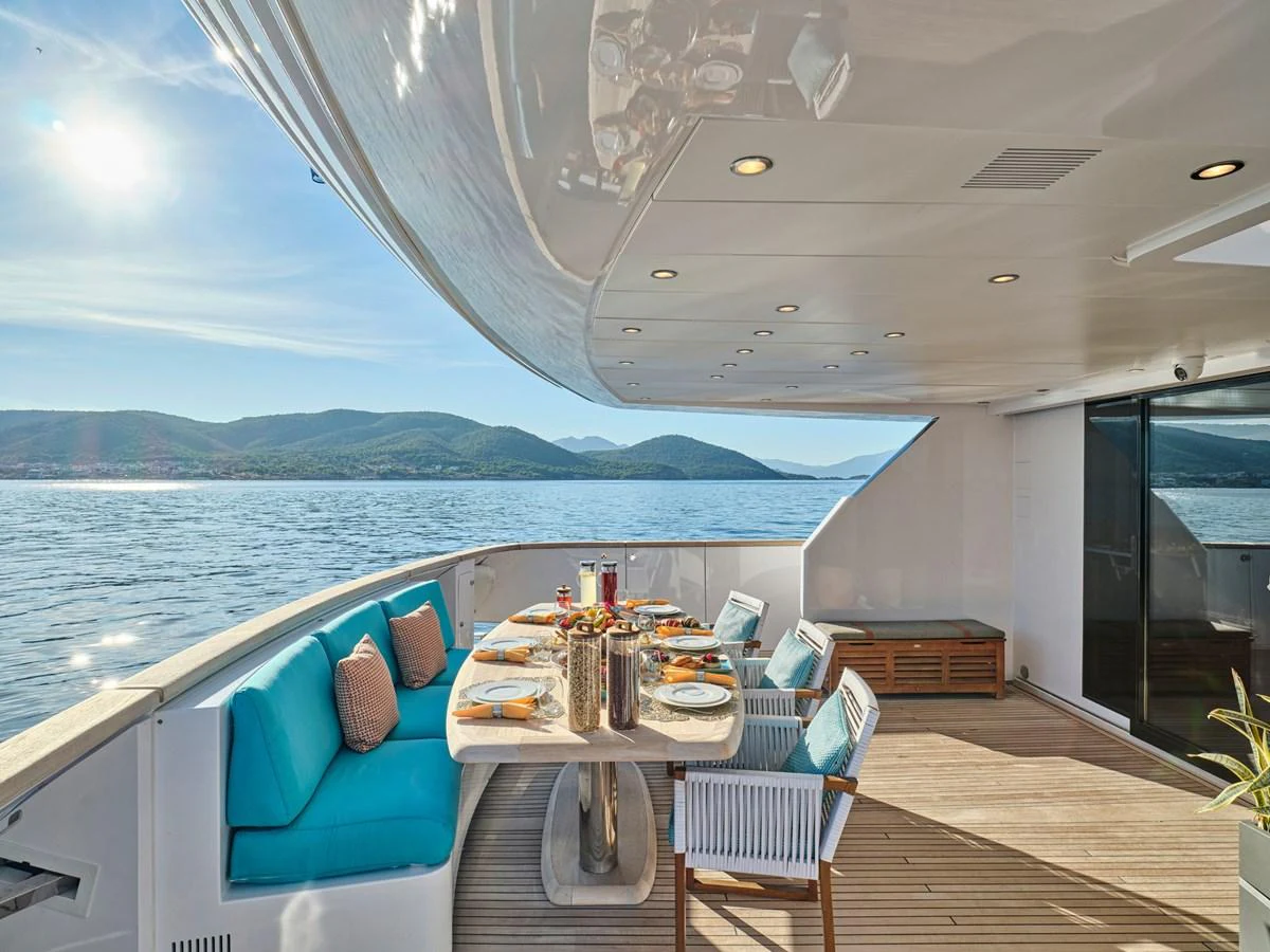 The aft deck features an elegant dining area with stunning views of the water and surrounding landscape. aboard VENETICO Yacht for Sale