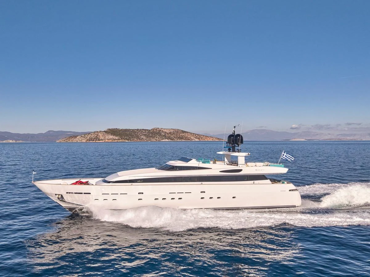 A sleek and modern yacht cruising on calm waters with an island in the background. aboard VENETICO Yacht for Sale