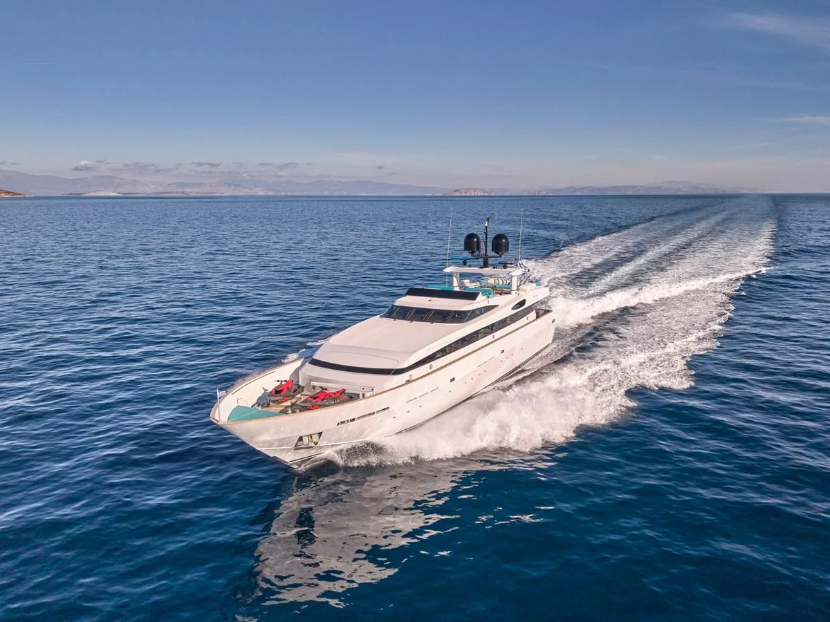 A sleek yacht cruises swiftly across calm, blue waters under a clear sky. aboard VENETICO Yacht for Sale