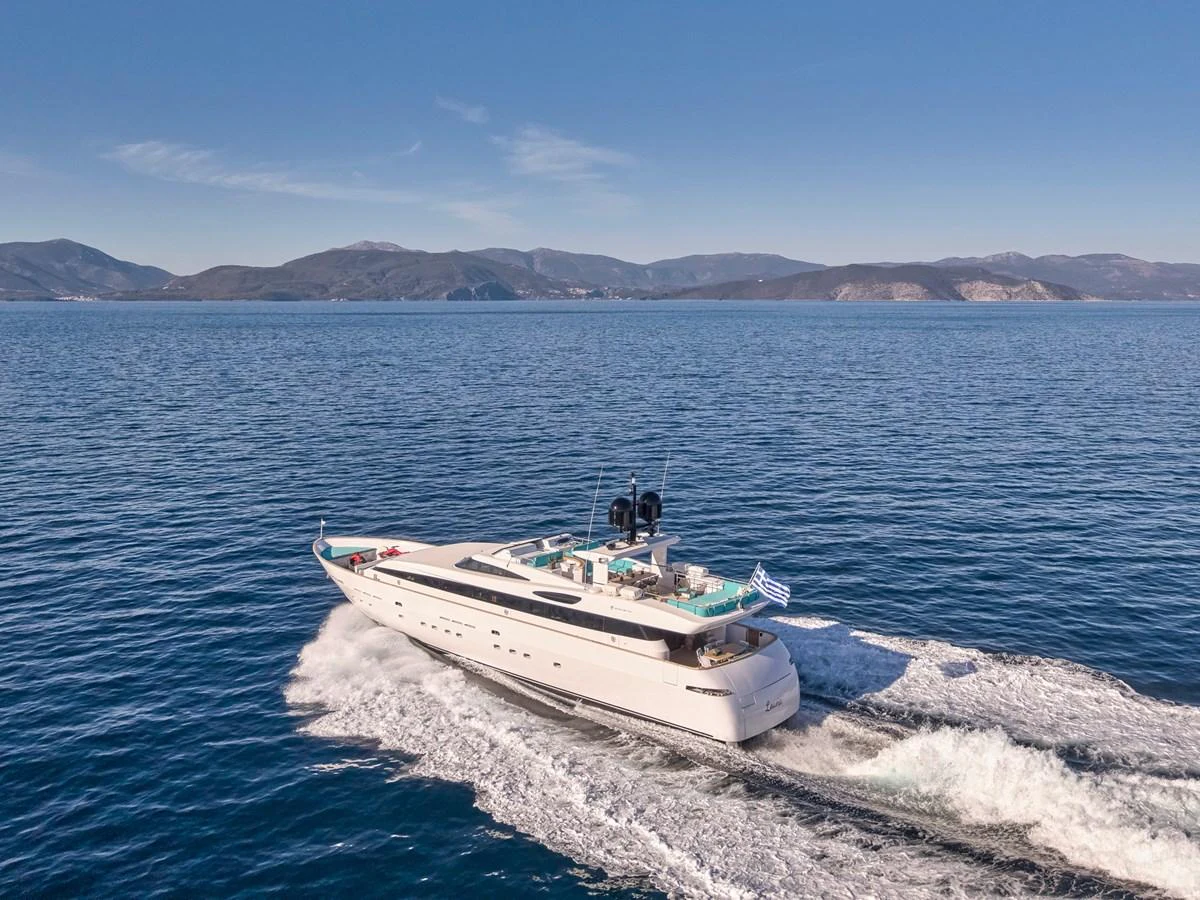 A sleek and modern yacht glides effortlessly across the open sea under a clear blue sky. aboard VENETICO Yacht for Sale
