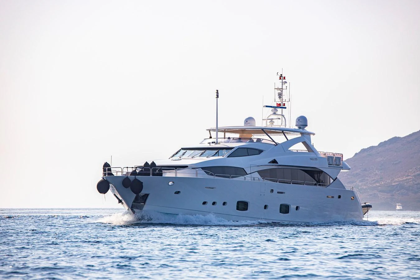 A sleek and modern yacht cruising on calm waters with a scenic backdrop. aboard FINAL CUT Yacht for Sale