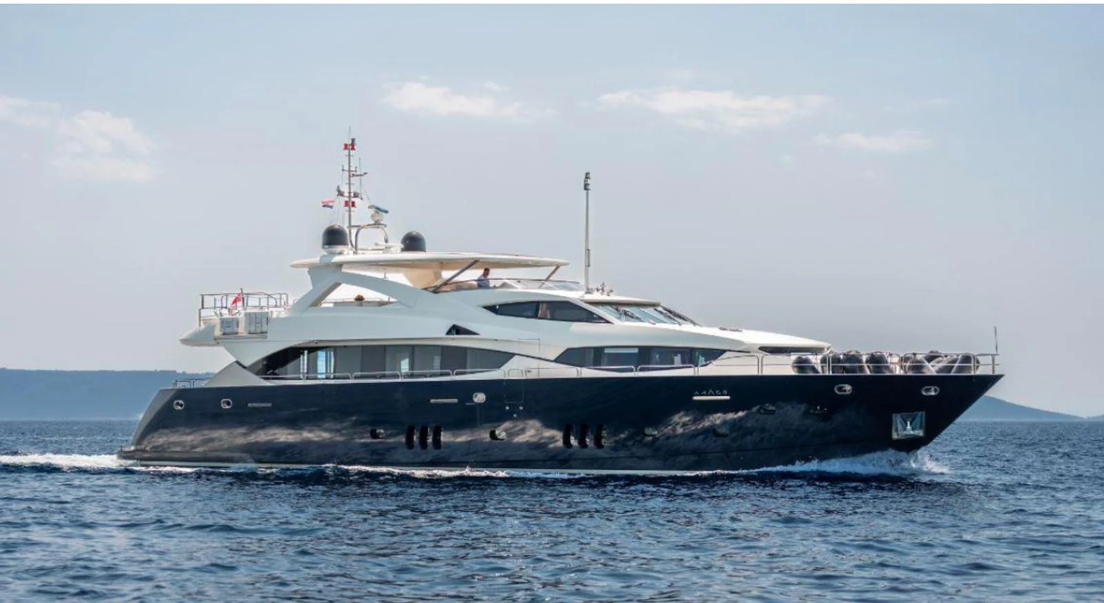 This sleek yacht glides gracefully on the open water, showcasing its elegant design and luxurious features. aboard ARAGO Yacht for Sale
