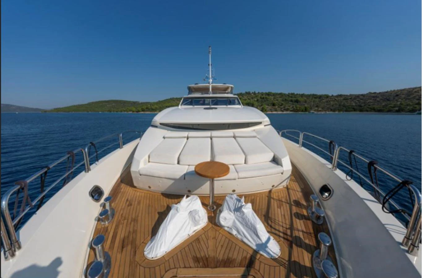 The foredeck features a spacious sunbathing area with plush cushions and a small table, perfect for relaxation. aboard ARAGO Yacht for Sale