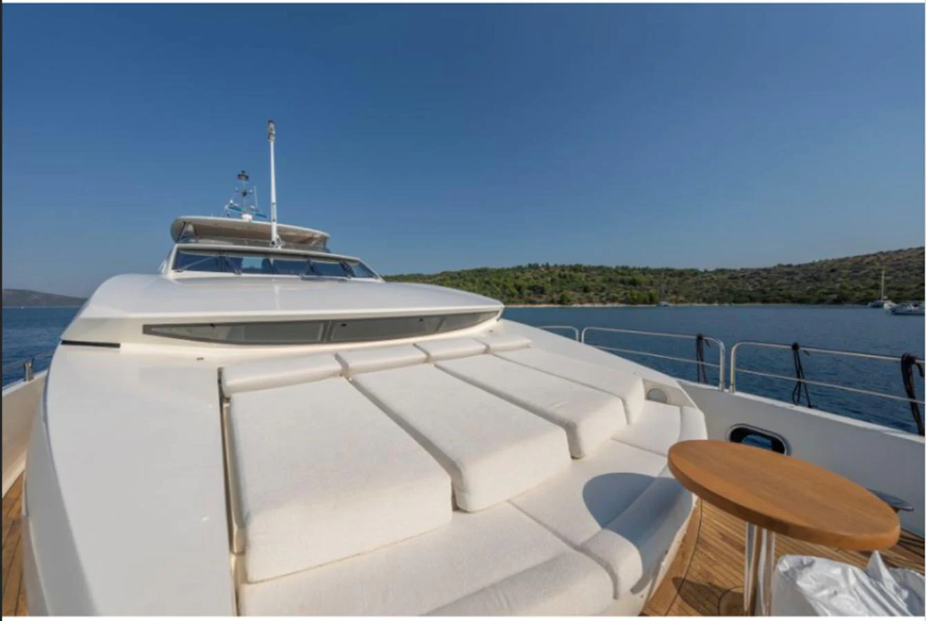 The foredeck features luxurious sun pads and a small table, perfect for relaxation while cruising. aboard ARAGO Yacht for Sale