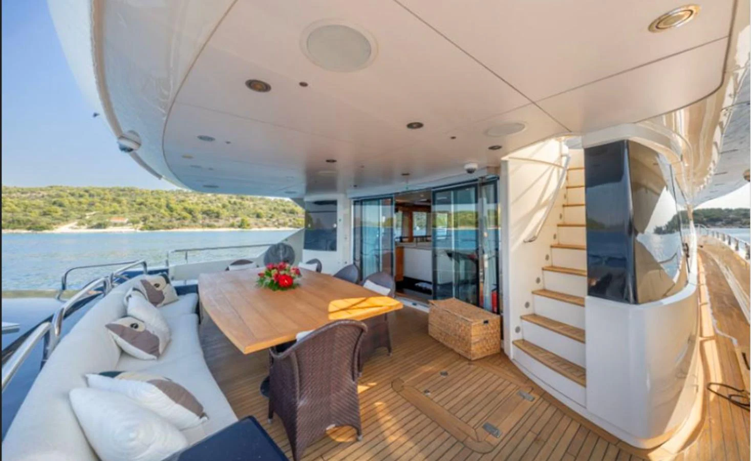 The aft deck features a spacious seating area with a dining table, perfect for alfresco meals and relaxation. aboard ARAGO Yacht for Sale