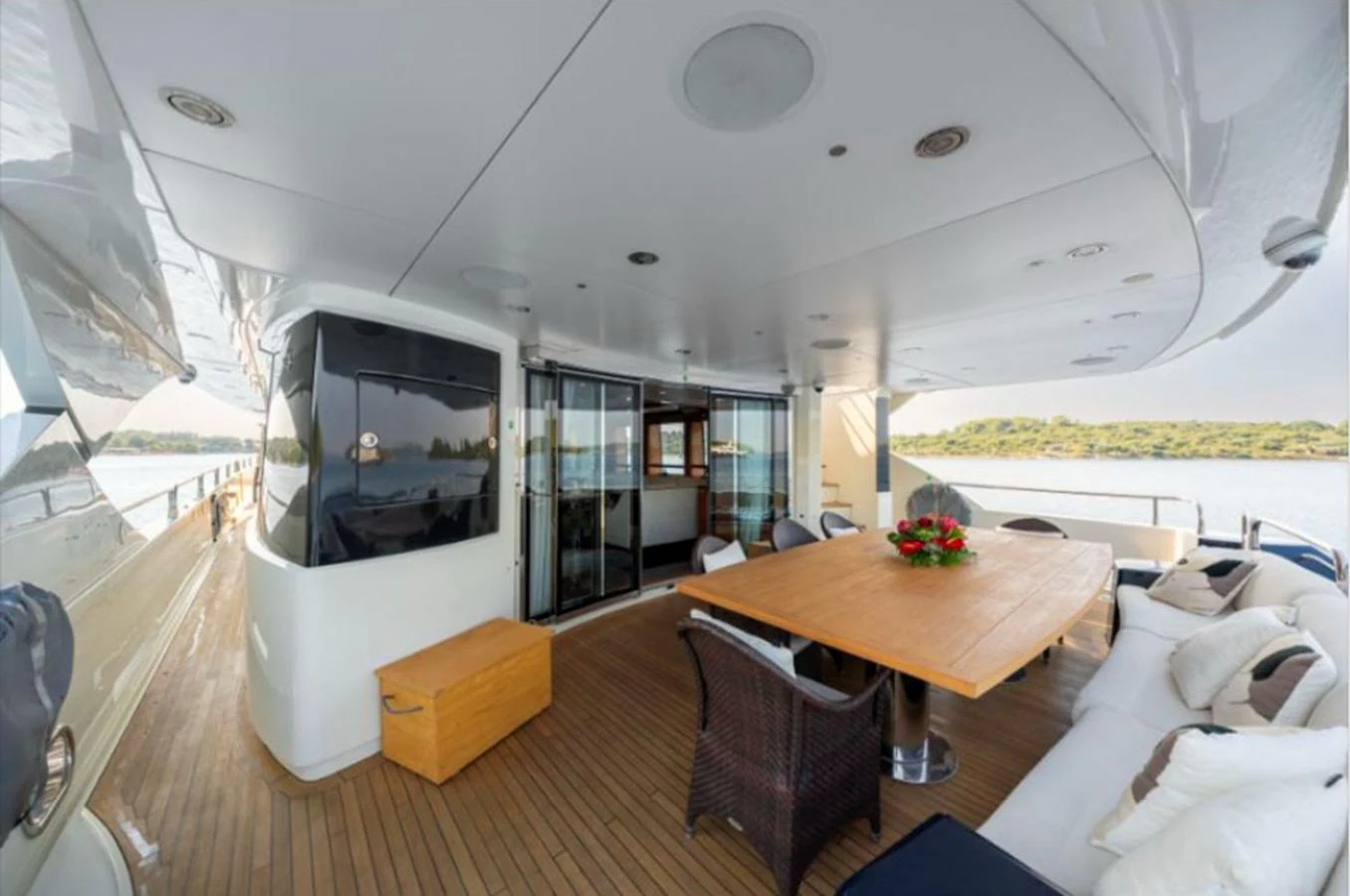 The aft deck features a spacious seating area with a large wooden table, perfect for alfresco dining. aboard ARAGO Yacht for Sale