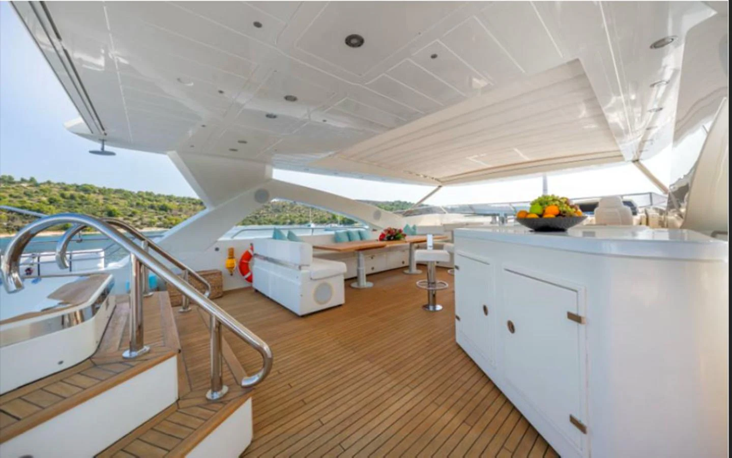 The aft deck features a spacious seating area with a bar and a jacuzzi, perfect for relaxation and entertainment. aboard ARAGO Yacht for Sale