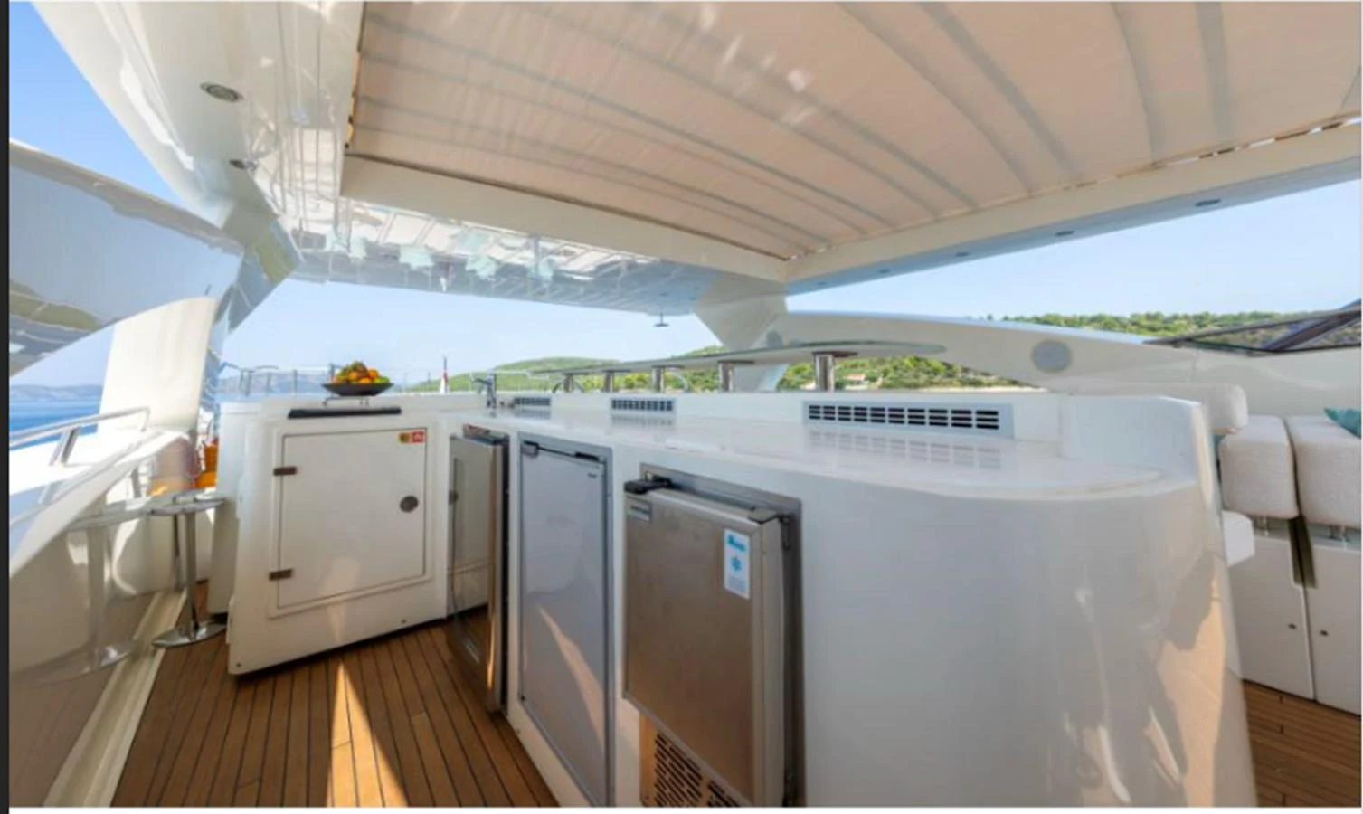 The flybridge features a well-equipped bar area with a scenic view. aboard ARAGO Yacht for Sale
