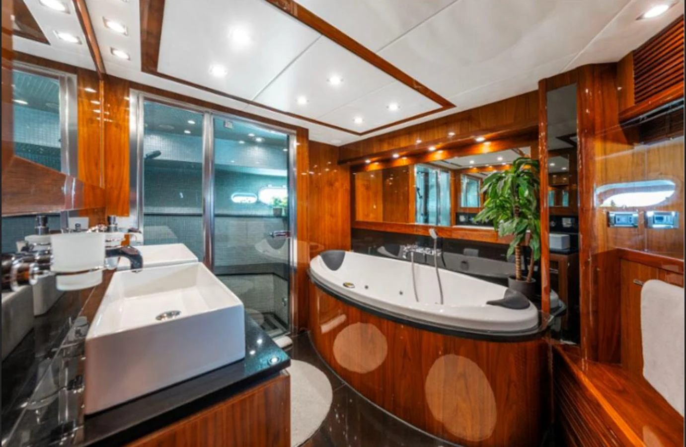 The yacht's bathroom features luxurious wood finishes, a large bathtub, and modern fixtures. aboard ARAGO Yacht for Sale
