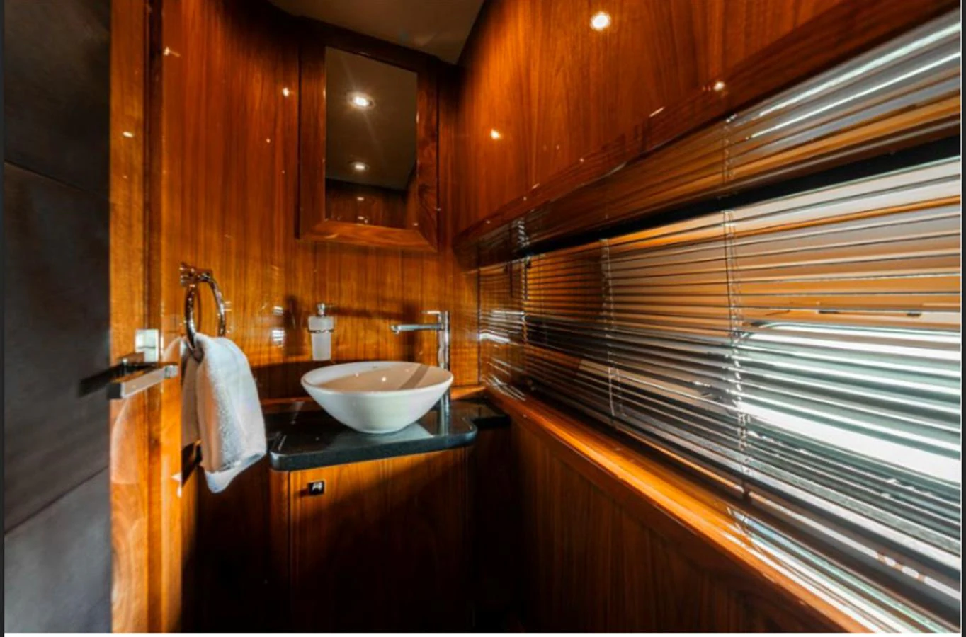 The yacht's bathroom features elegant wood paneling and modern fixtures. aboard ARAGO Yacht for Sale