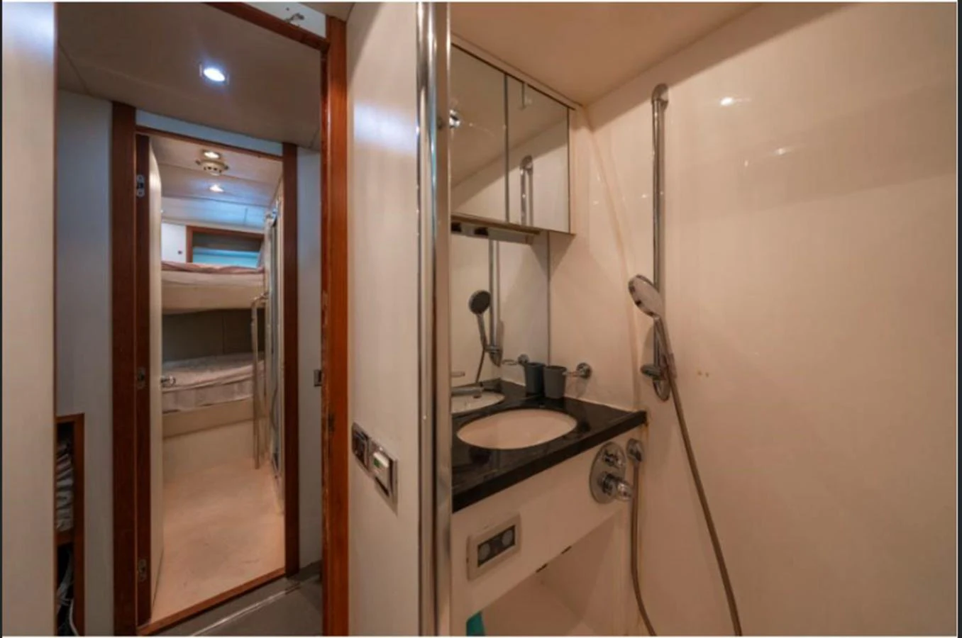 A compact and well-appointed yacht bathroom with a view into a cozy sleeping area. aboard ARAGO Yacht for Sale